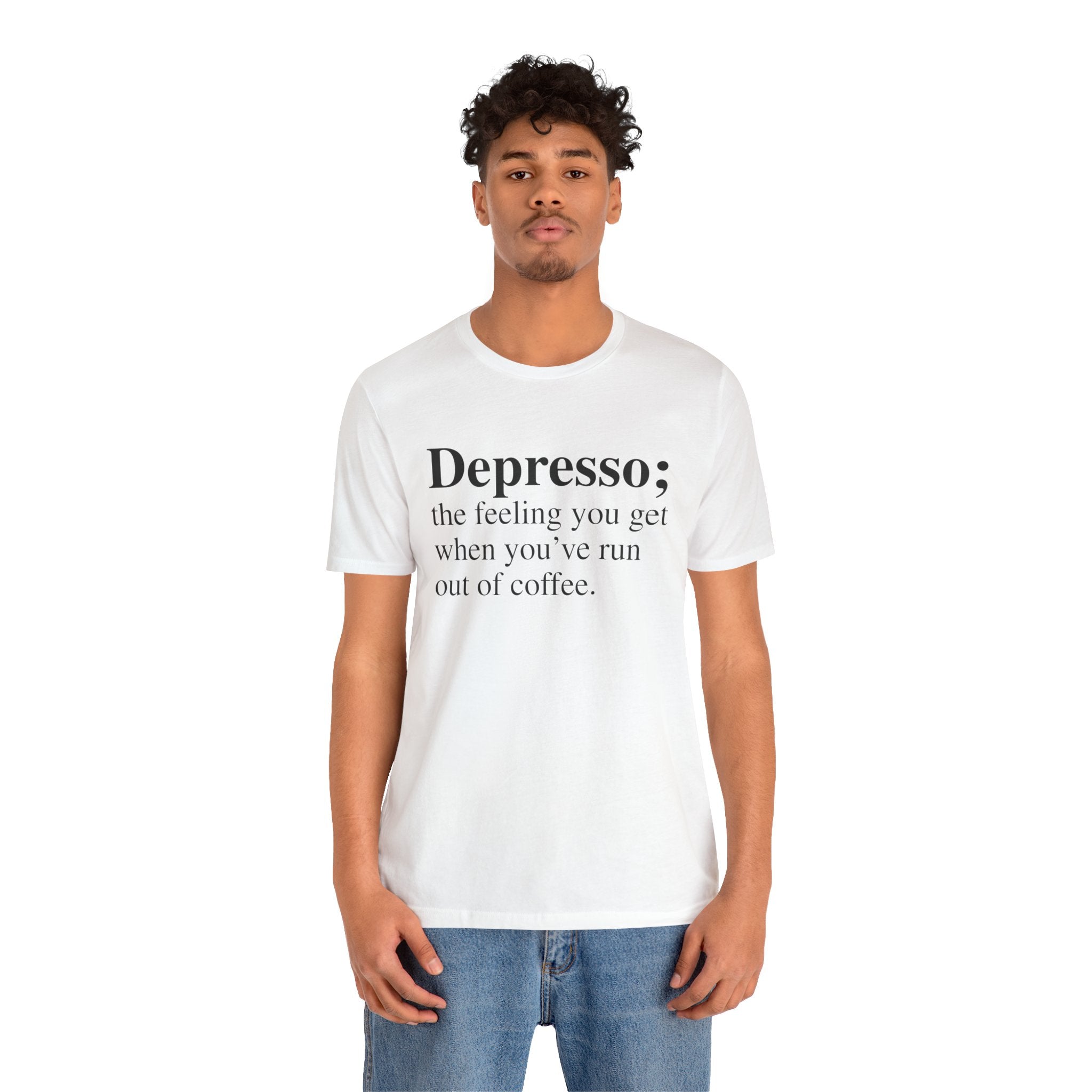 A young man wearing a soft cotton Depresso T-Shirt, with the text "depresso; the feeling you get when you've run out of coffee," stands against a plain background.