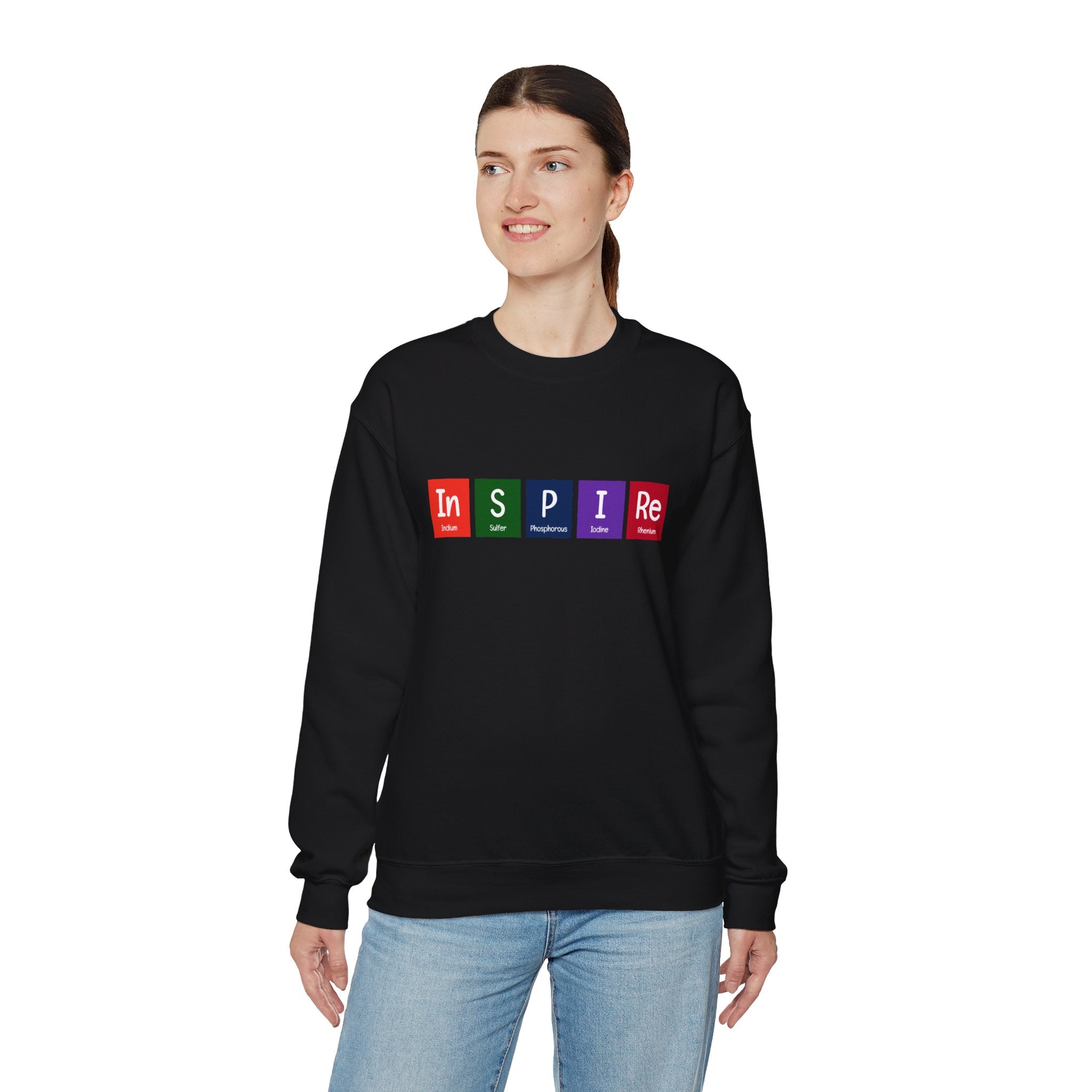 A person wearing a cozy black In-S-P-I-Re - Sweatshirt that has the word "INSPIRE" printed on it, with each letter in a colored box. Perfect for the colder months, they are standing against a white background.