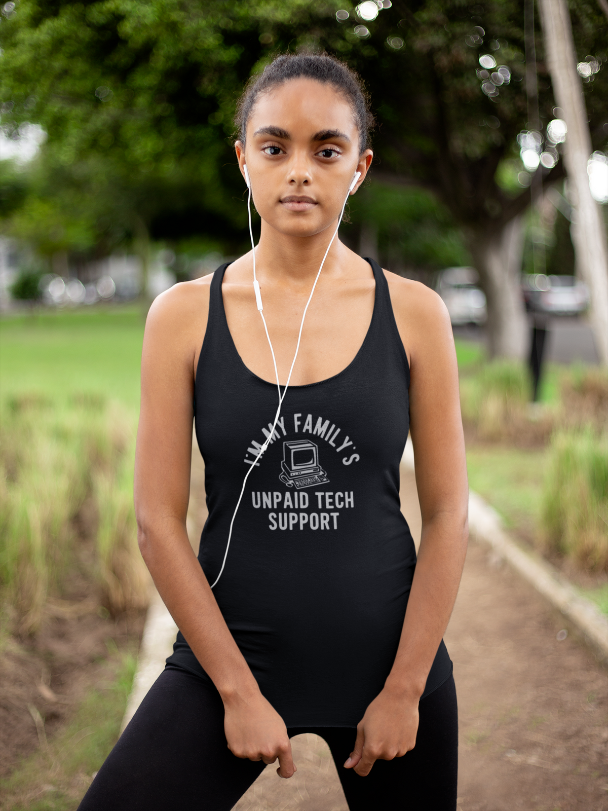 'I Am My Family's Unpaid Tech Support Tank' in black, woman in a park, Tank Top mockup, Geekpsters
