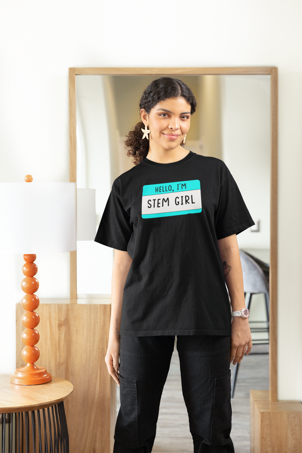 Hello I'm Stem Girl name tag T-shirt in black, woman wearing it indoors, funny science gift tee for her