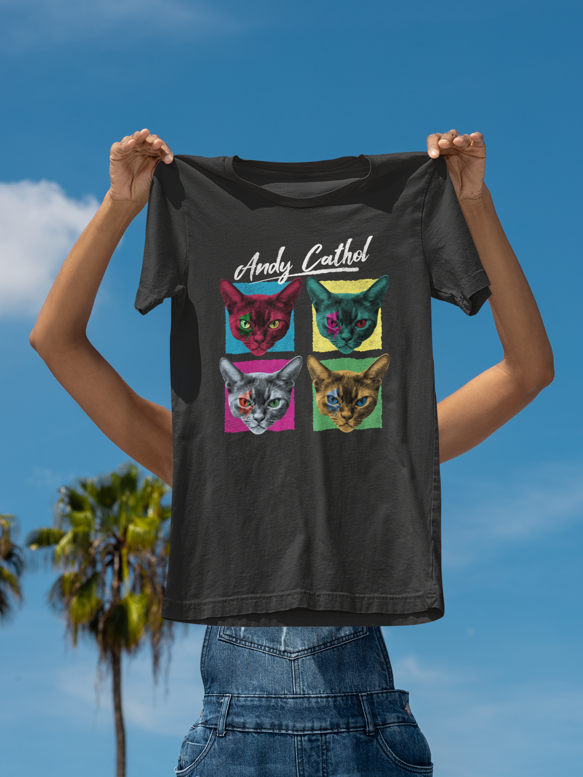 'Andy Cathol' pop art t-shirt in black, man holding it up on sky backdrop, funny cat lover gift