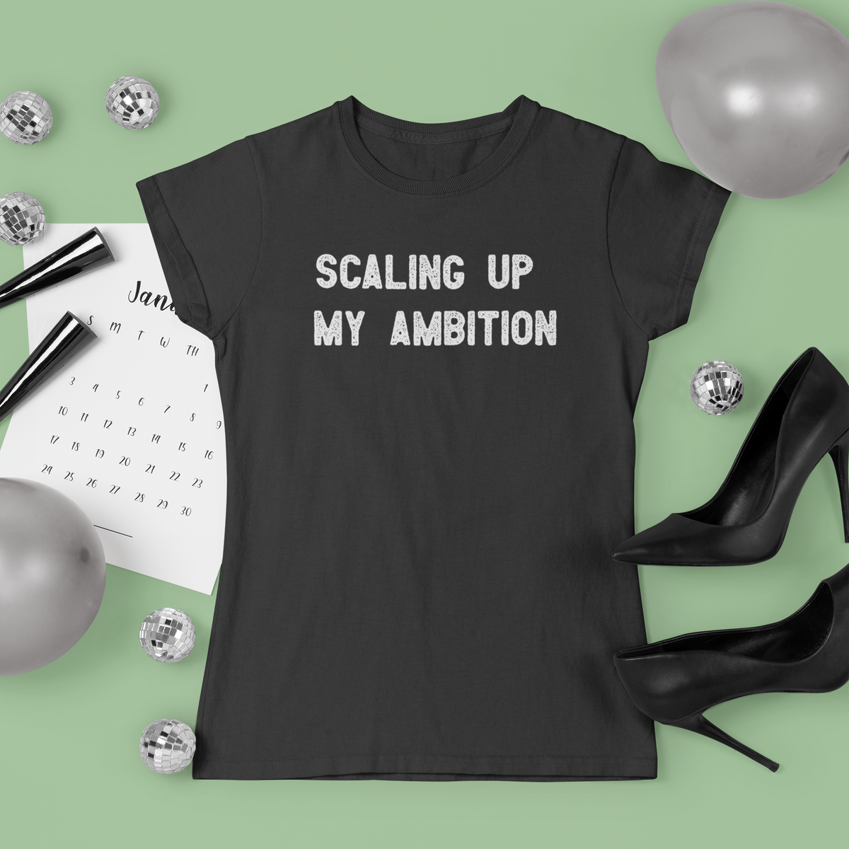 'Scaling Up My Ambition' t-shirt in black, styled flat lay with heels and balloons, funny gift for her