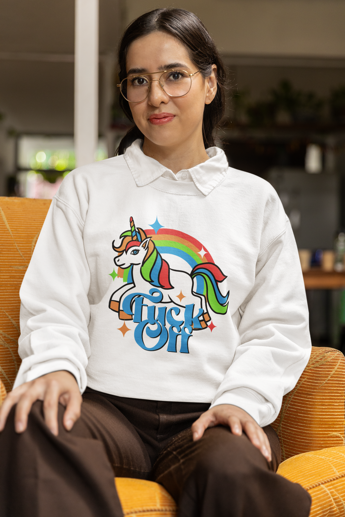 F Off Sweatshirt in white, woman sitting wearing it indoors, funny unicorn graphic sweatshirt