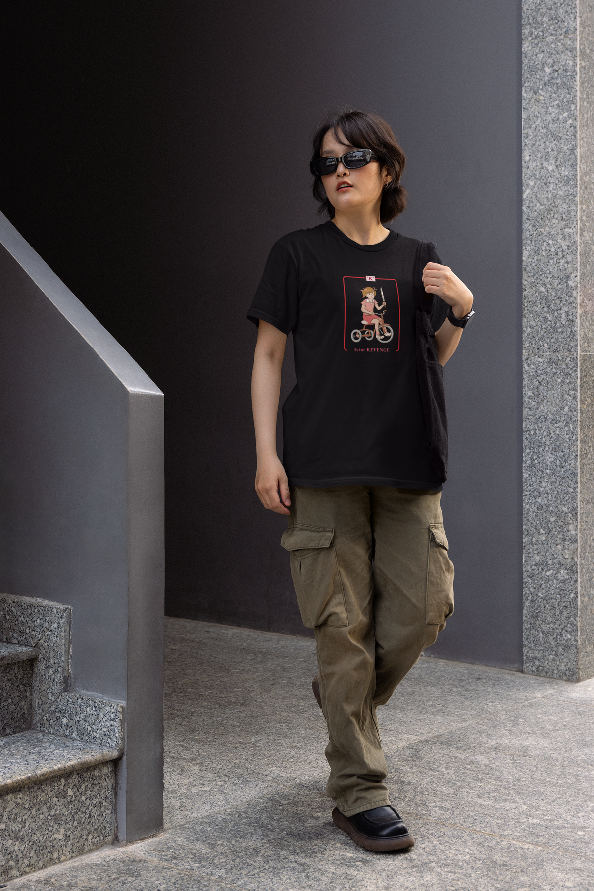 'R is for Revenge' tricycle girl graphic women's tee in black, man walking in urban setting, funny gift
