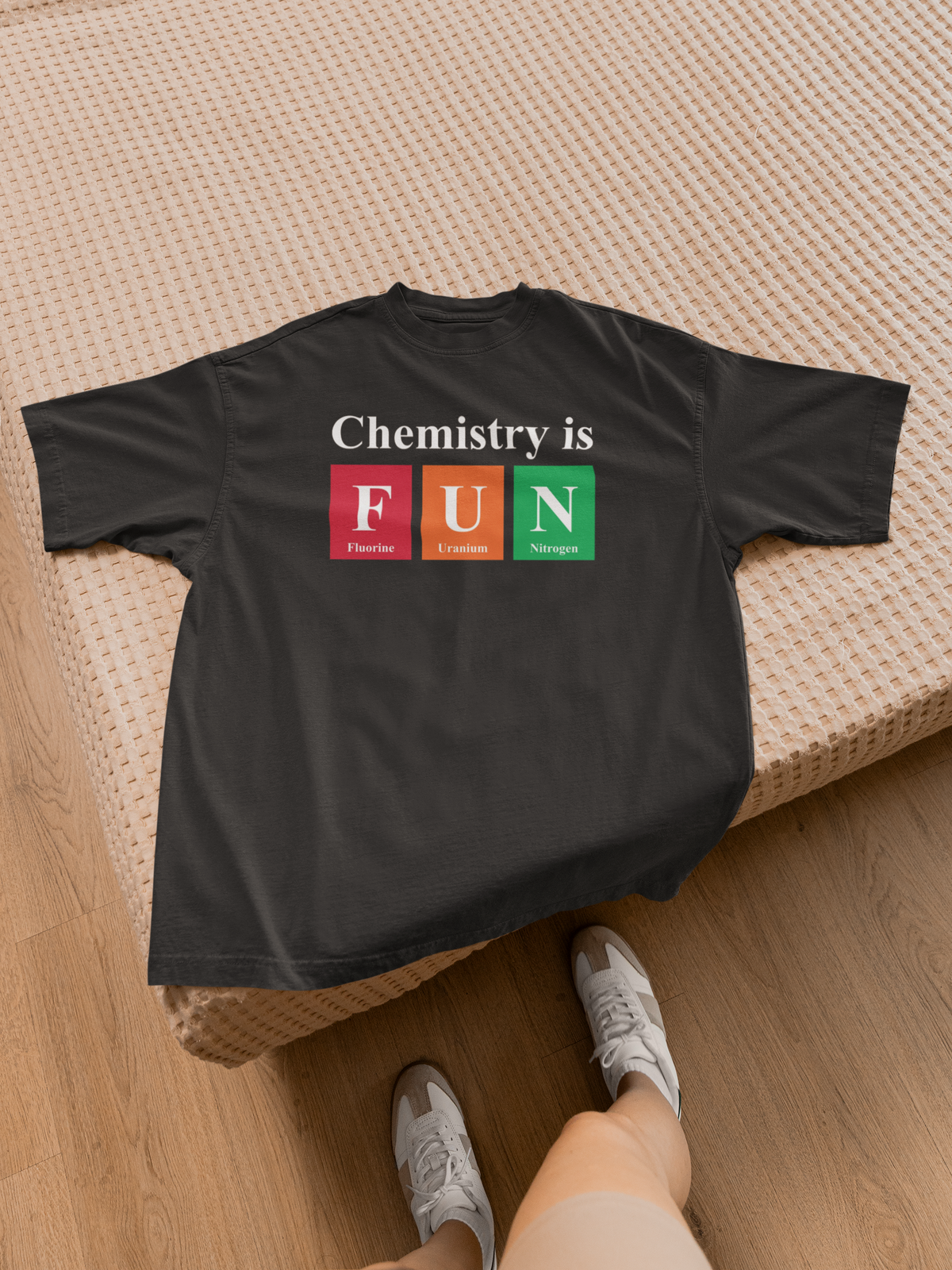 'Chemistry is FUN' graphic t-shirt in black, flat lay on floor with sneakers, casual science teacher gift