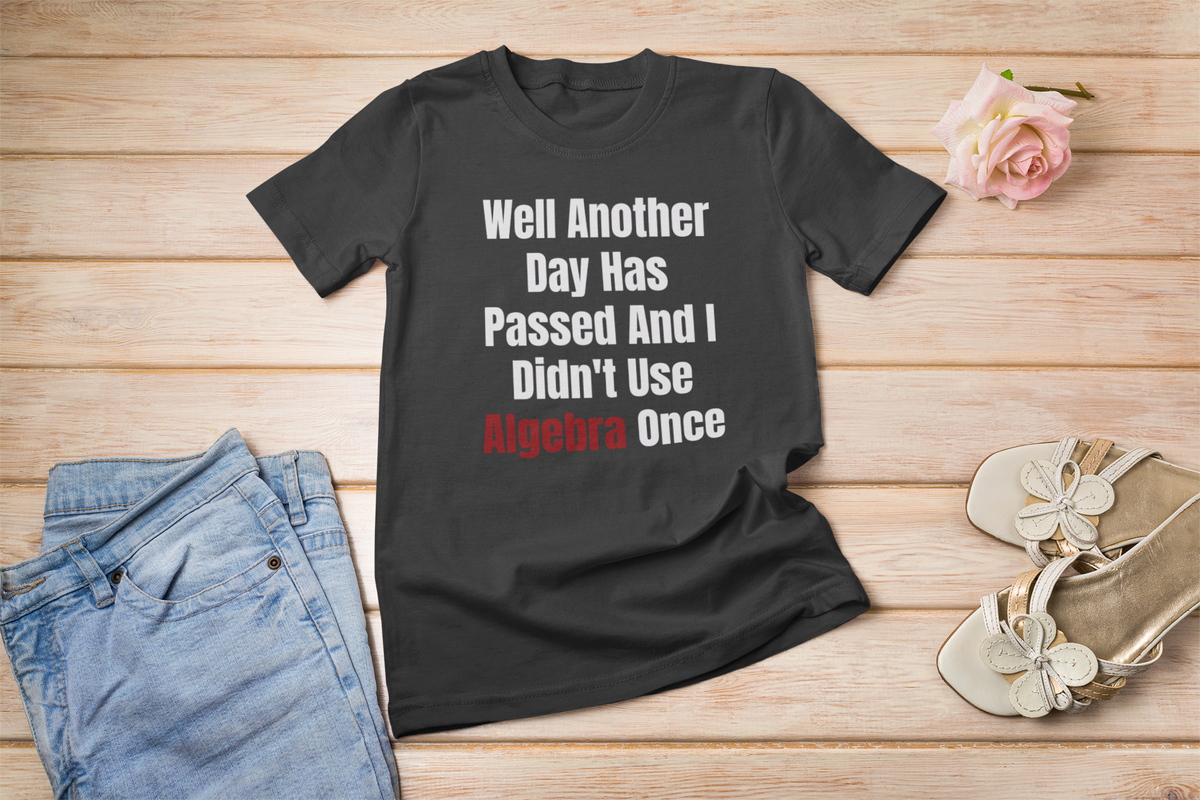 "Well Another Day Has Passed And I Didn't Use Algebra Once" t-shirt in black, flat lay with flowers
