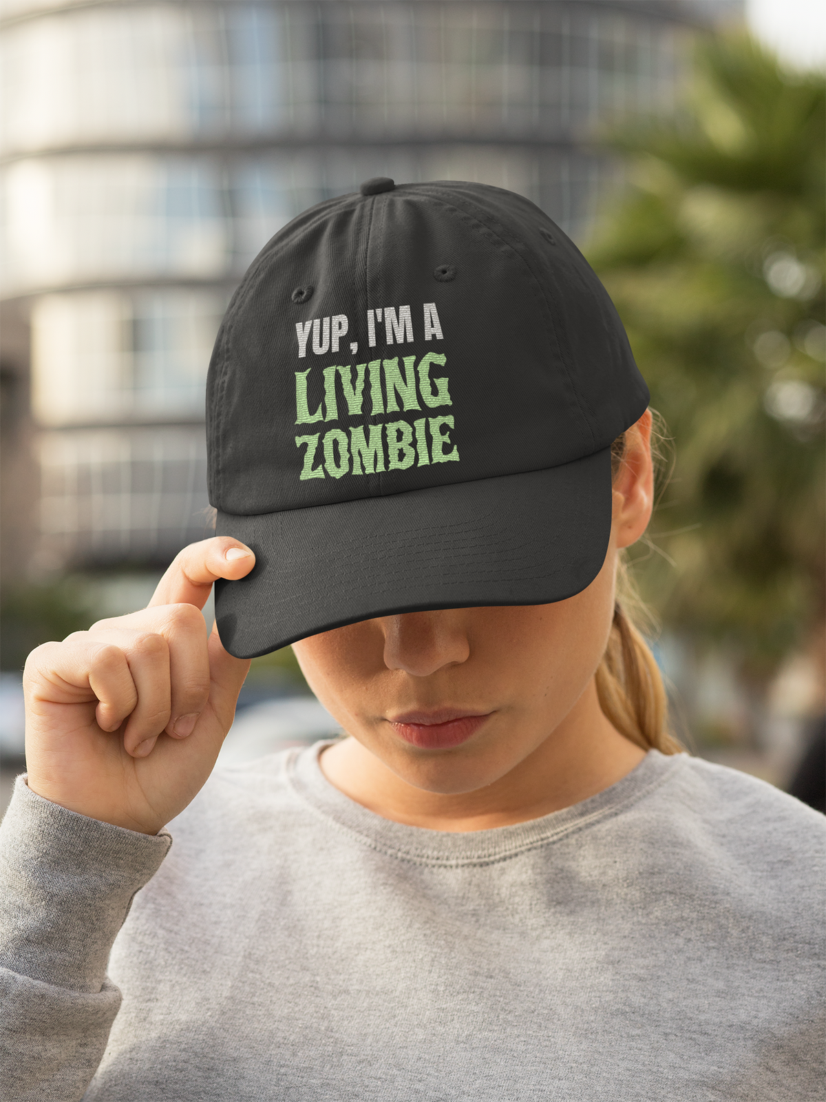 'Yup, I'm a Living Zombie' dad hat in black, woman wearing it outdoors, funny zombie hat gift idea