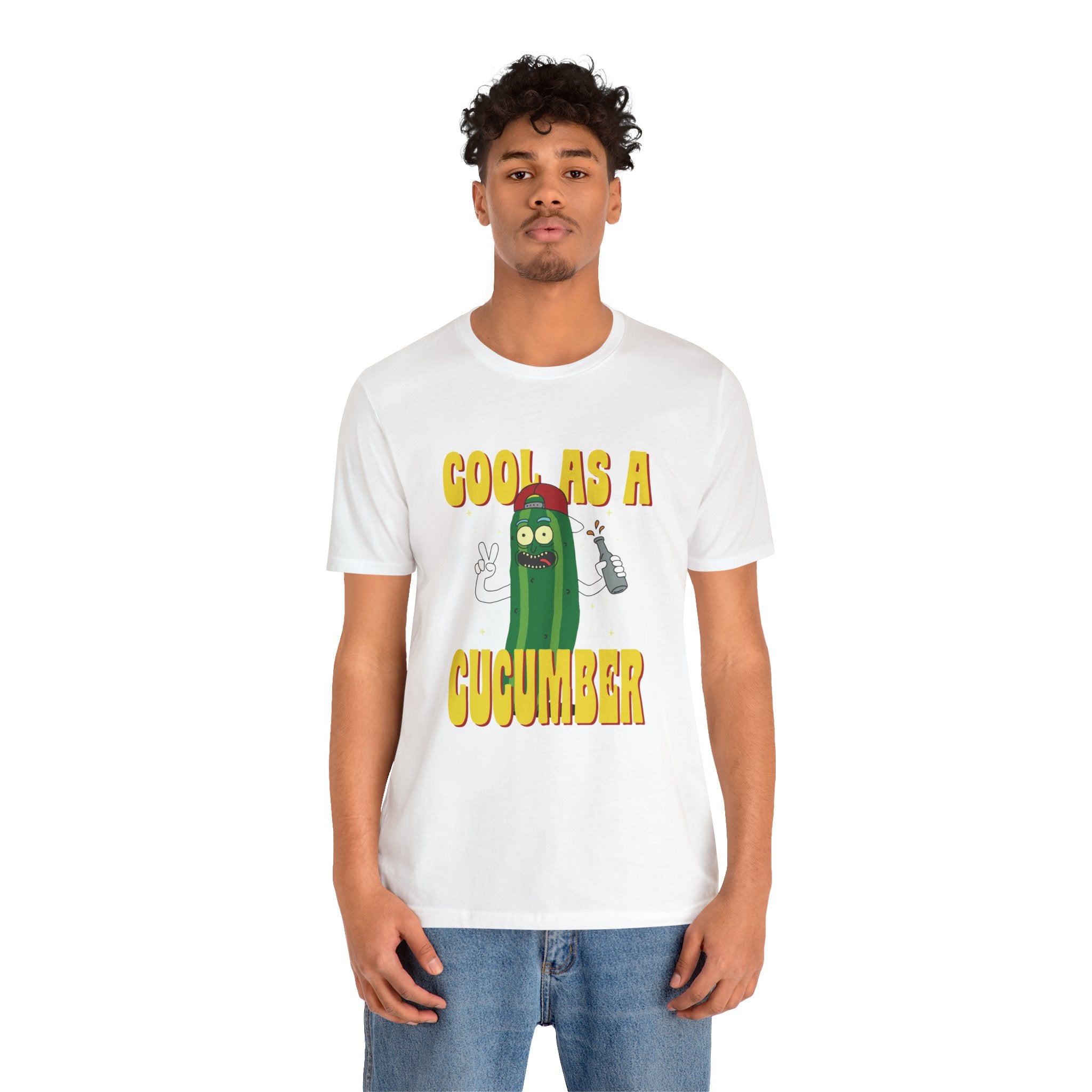A man in a Cool as a Cucumber, white unisex jersey tee featuring the phrase "cool as a cucumber" with an illustration of a smiling cucumber wearing sunglasses.
