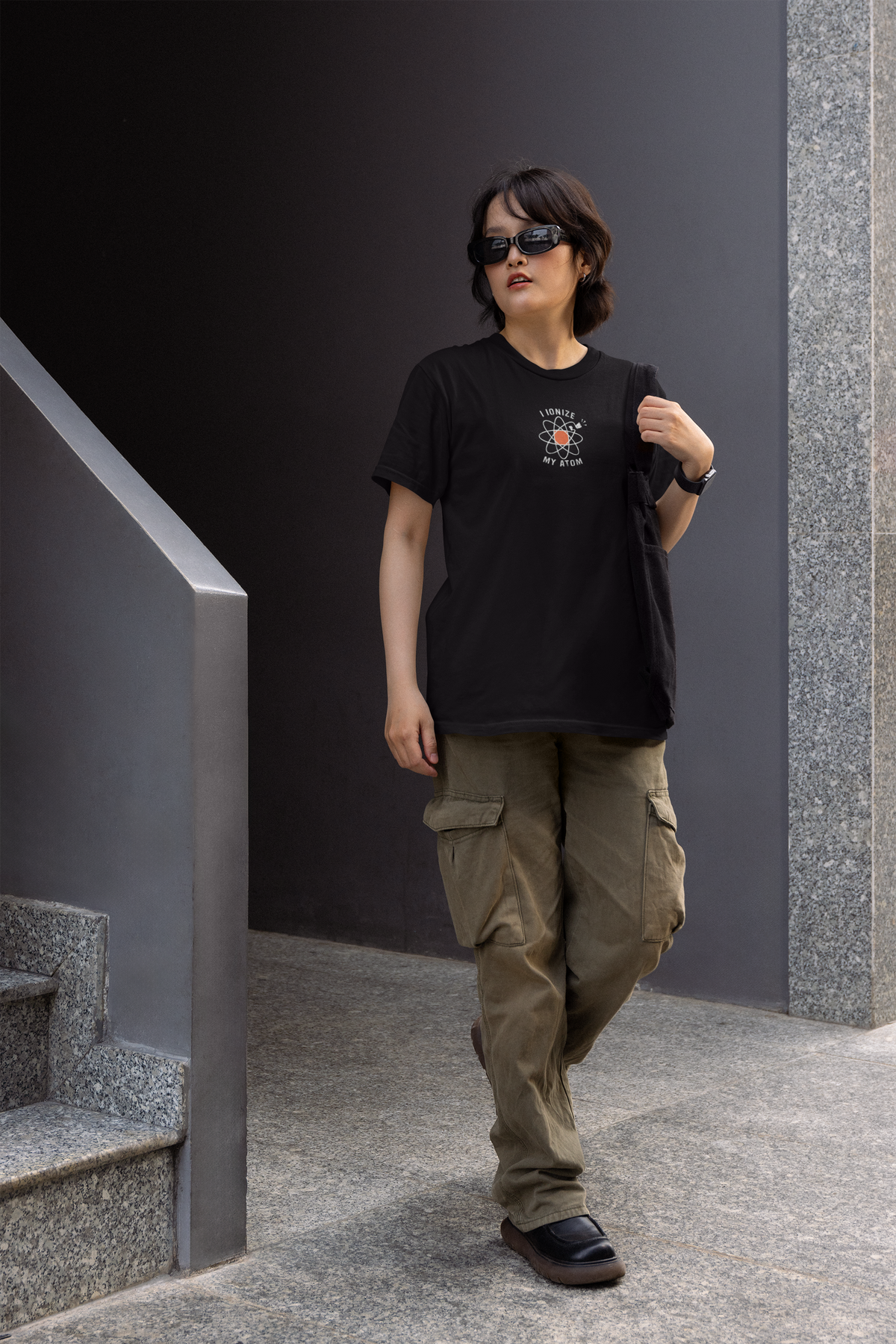 'I Ionize My Atom' womens tee in black, man walking outdoors wearing it, funny science pun gift