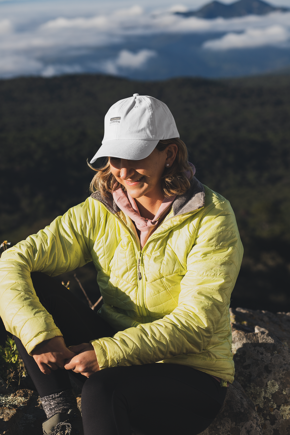 Adulthood is a Trap sarcastic dad hat, woman on a mountain hike, lifestyle mockup, Geekpsters