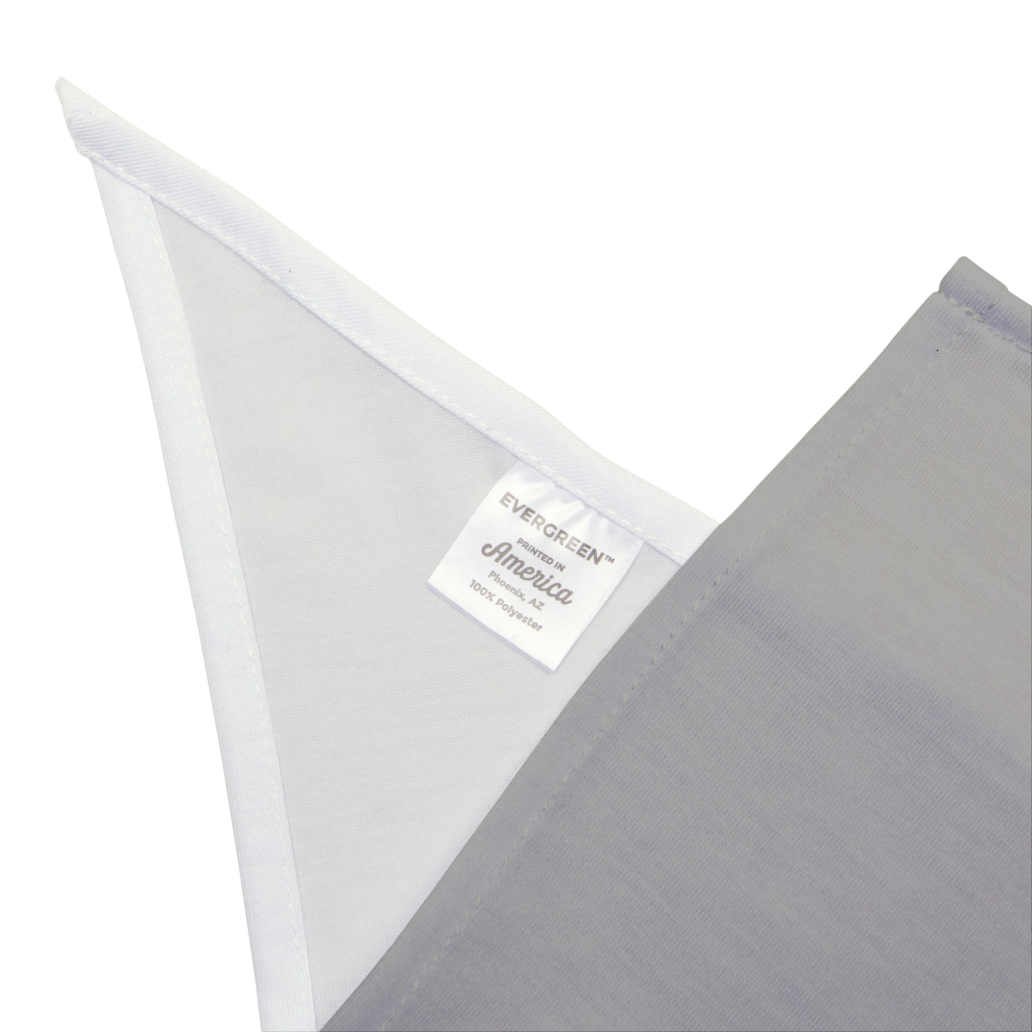 Close-up of a light grey fabric with a white triangular corner, reminiscent of the soft-spun polyester used in Mocha - Pet Bandana. Attached tag reads "EVERGREEN America 100% polyester.