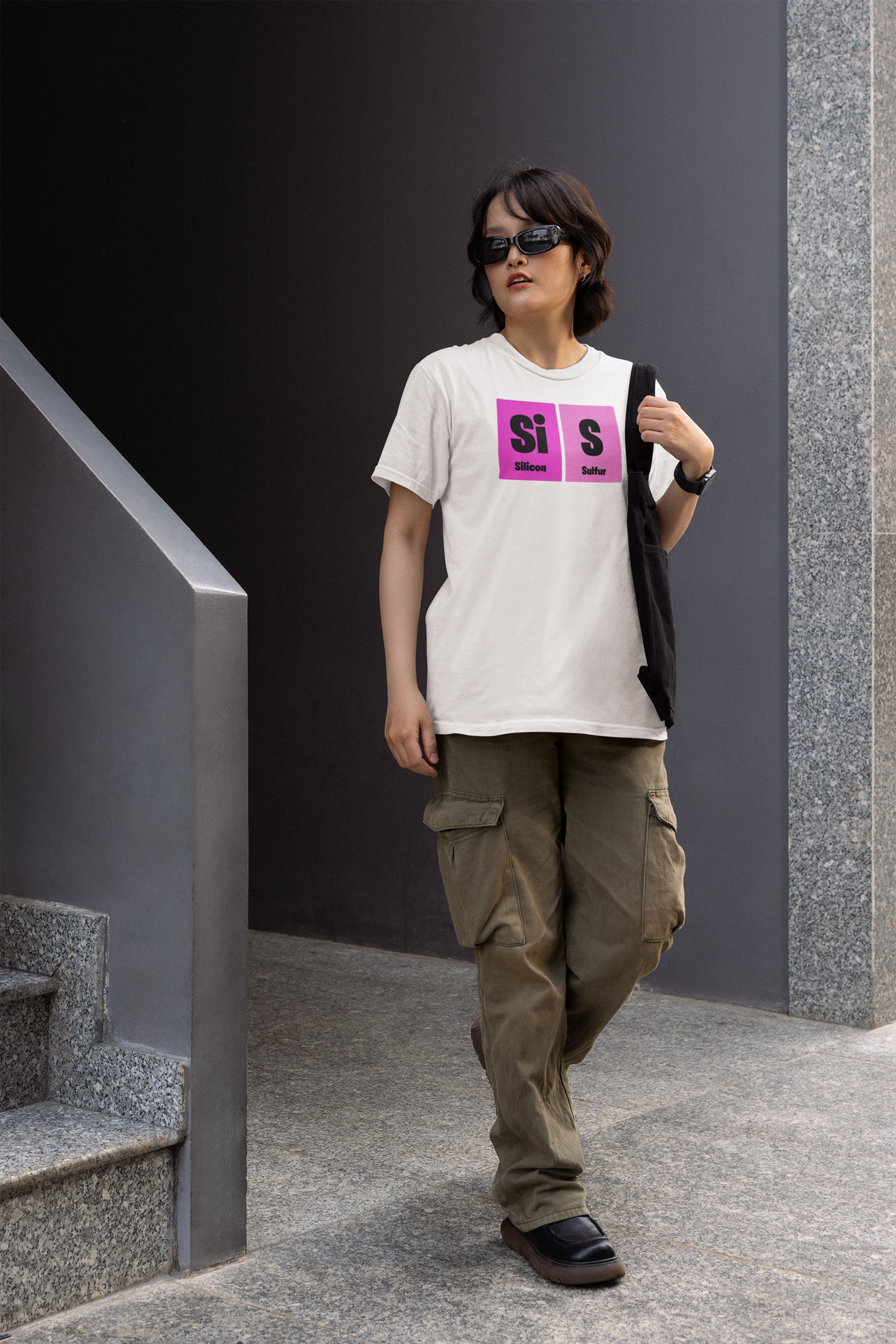 'Sis' periodic table women's tee in white, man walking outdoors, casual streetwear photo