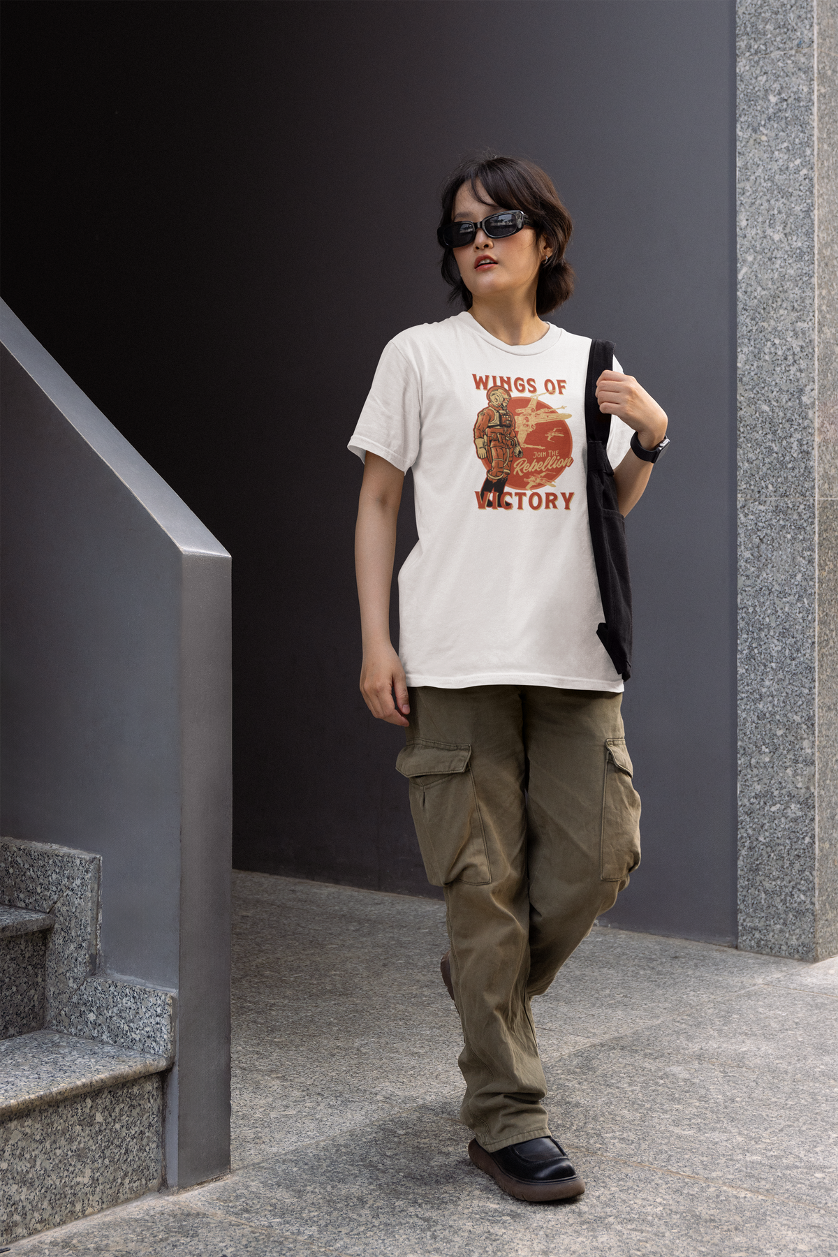 'Wings of Victory' women's tee in white, woman wearing it walking outdoors, rebel warrior graphic tee