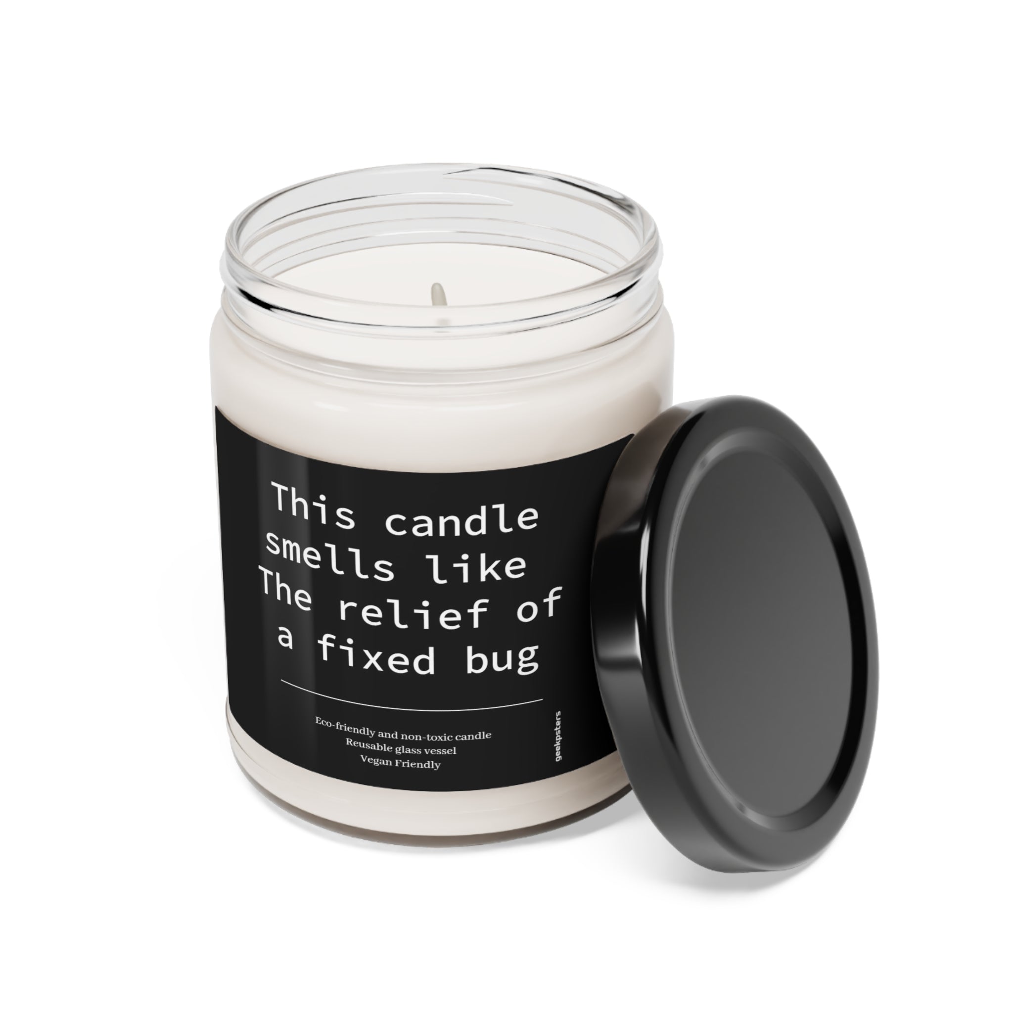 A white soy candle in a clear glass jar with a black lid, labeled "This Candle Smells Like The Relief of a Fixed Bug." The jar stands on a white background.