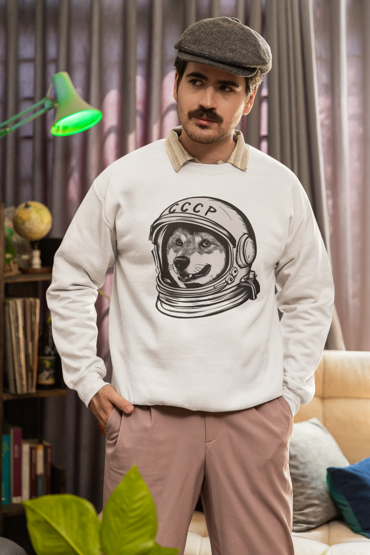'CCCP Astronaut Dog' sweatshirt in white, man wearing it in a cozy living room, funny retro space dog gift