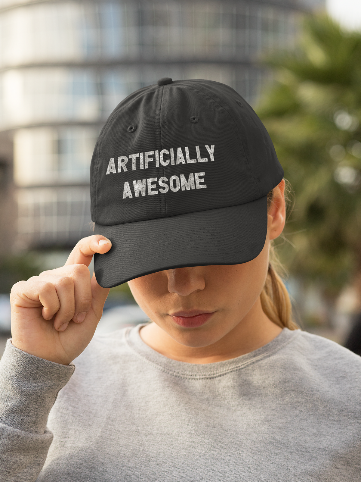 'Artificially Awesome' dad hat in black, woman wearing it outdoors in city, cool cap gift for AI enthusiasts