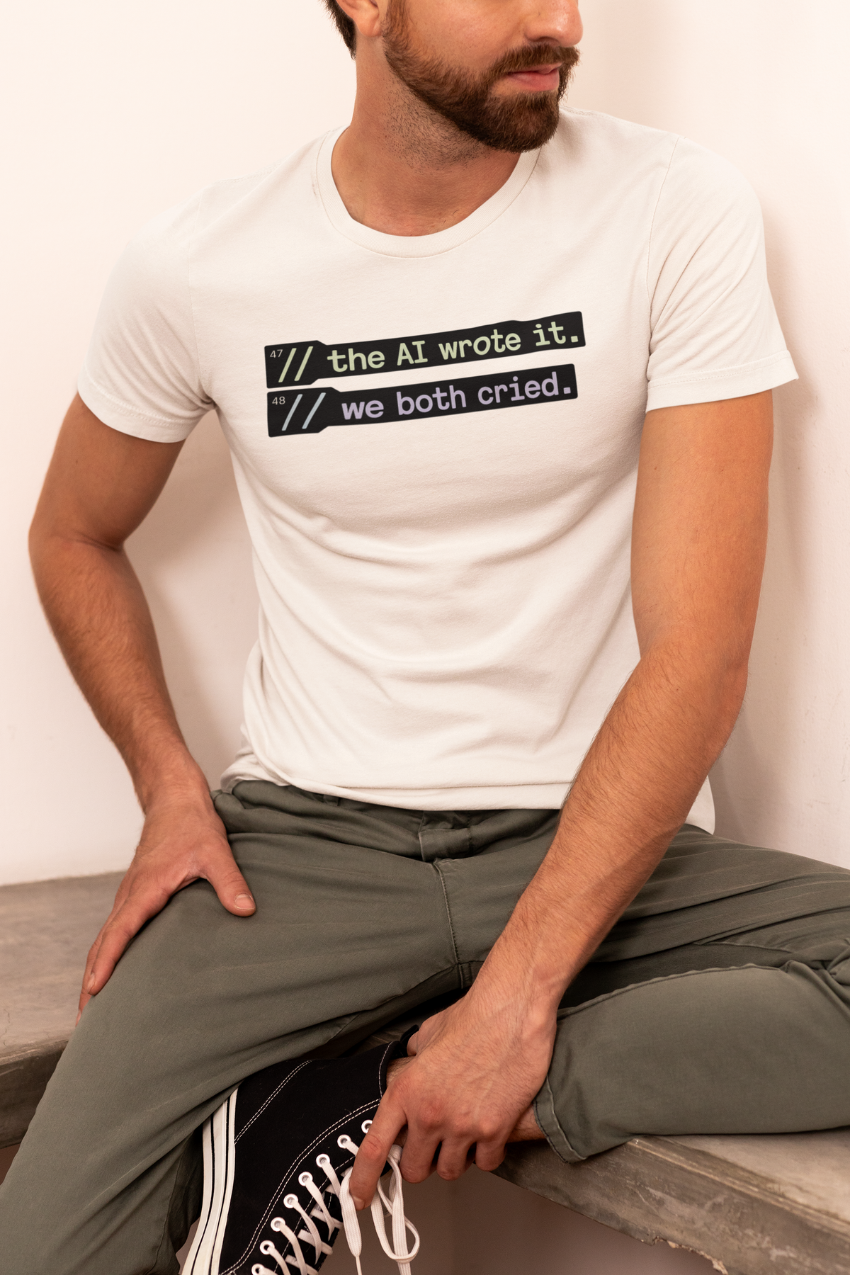 'The AI wrote it. We both cried.' cream tee worn by seated man, fun gift idea