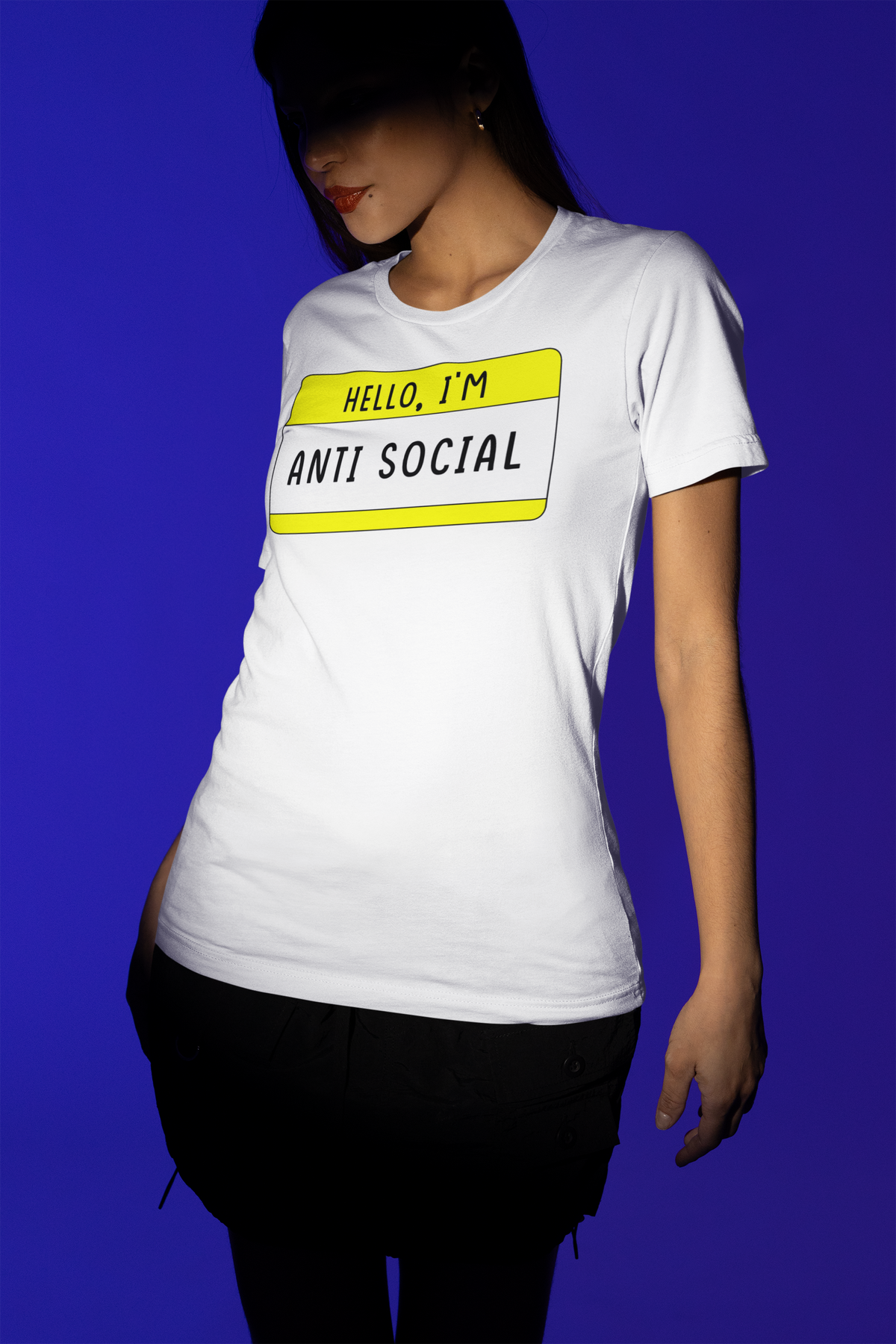 Hello I'm Anti Social name tag T-shirt in white, woman wearing it against a blue backdrop, gift tee