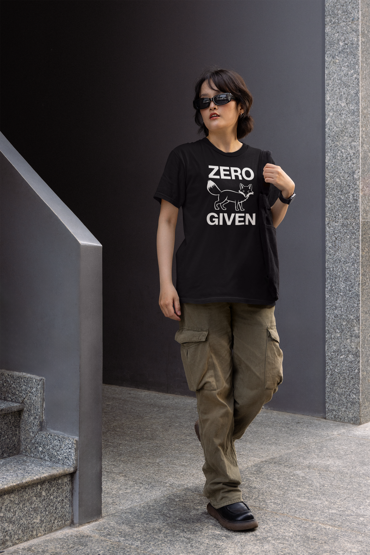 "Zero Fox Given" women's tee in black, woman walking outdoors near stairs, funny sarcastic gift