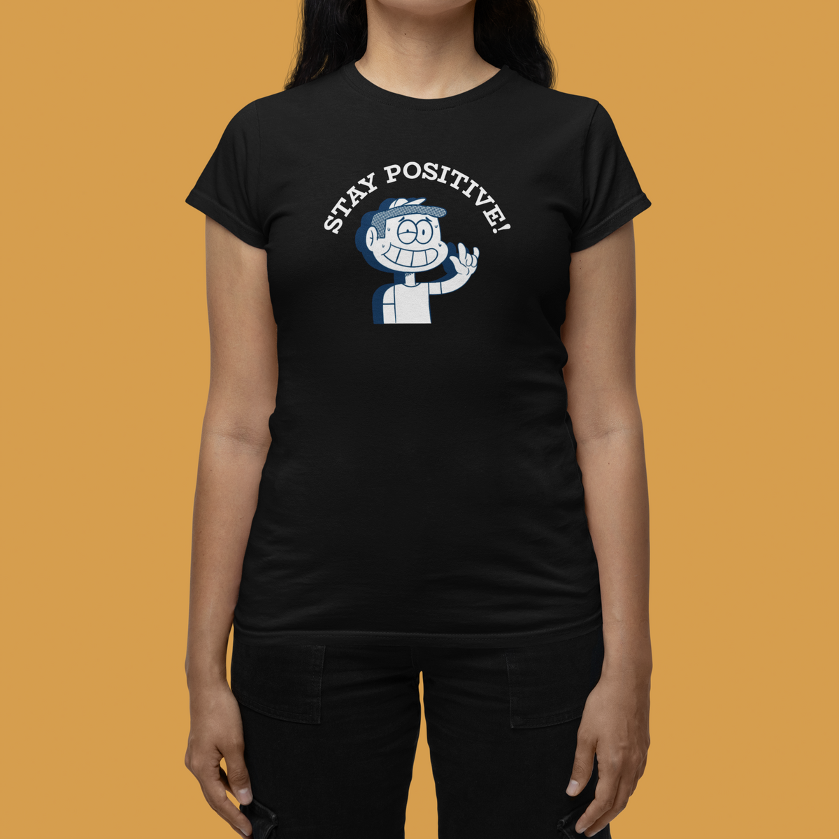 'Stay Positive!' t-shirt in black, woman wearing it against a yellow backdrop, funny cartoon motivational tee