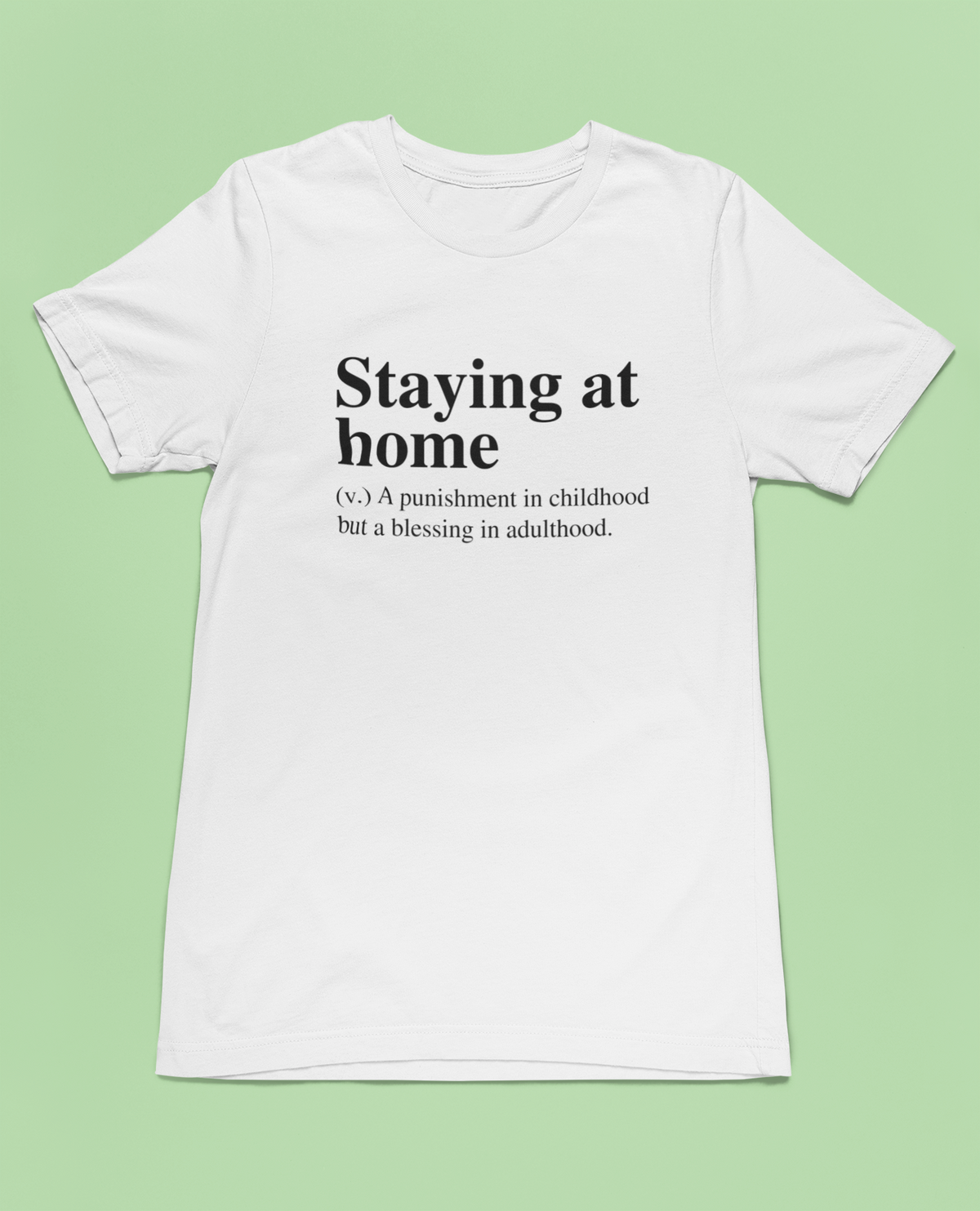 'Staying at Home' definition T-shirt in white, flat lay on pale green background, funny introvert tee