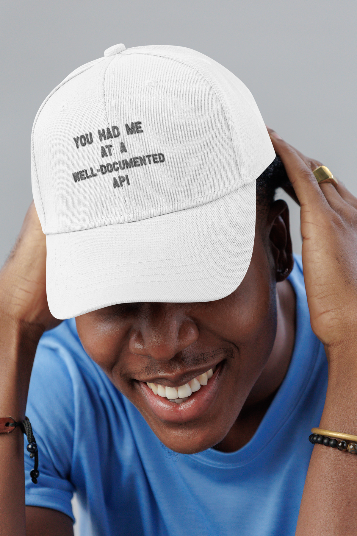Well-Documented API embroidered dad hat worn by a smiling man in a studio, lifestyle mockup, Geekpsters