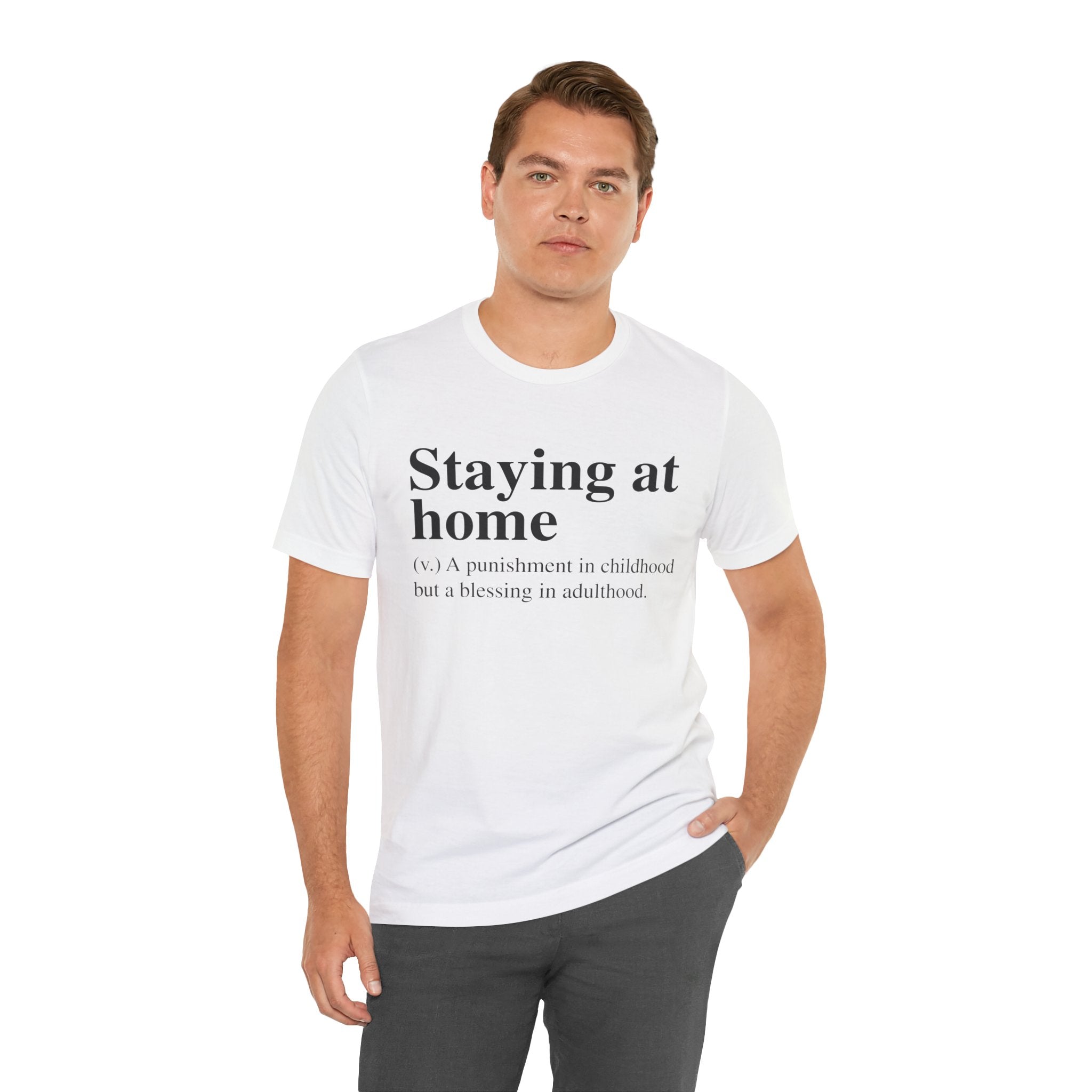 Man wearing a Staying at Home T-Shirt with the text "staying home (v.) a punishment in childhood but a blessing in adulthood" printed on it.
