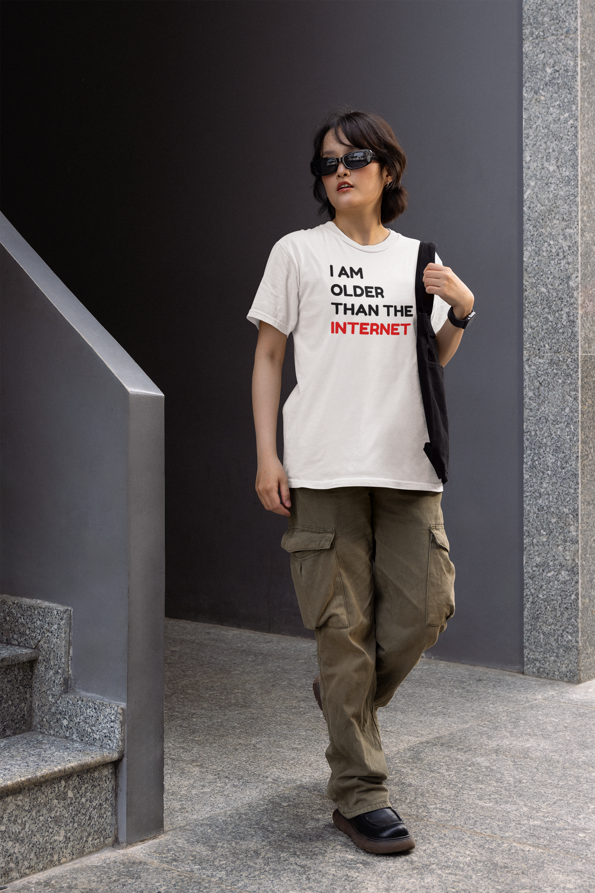 'I Am Older Than the Internet' t-shirt in white, person wearing it outdoors on stairs, funny retro statement gift