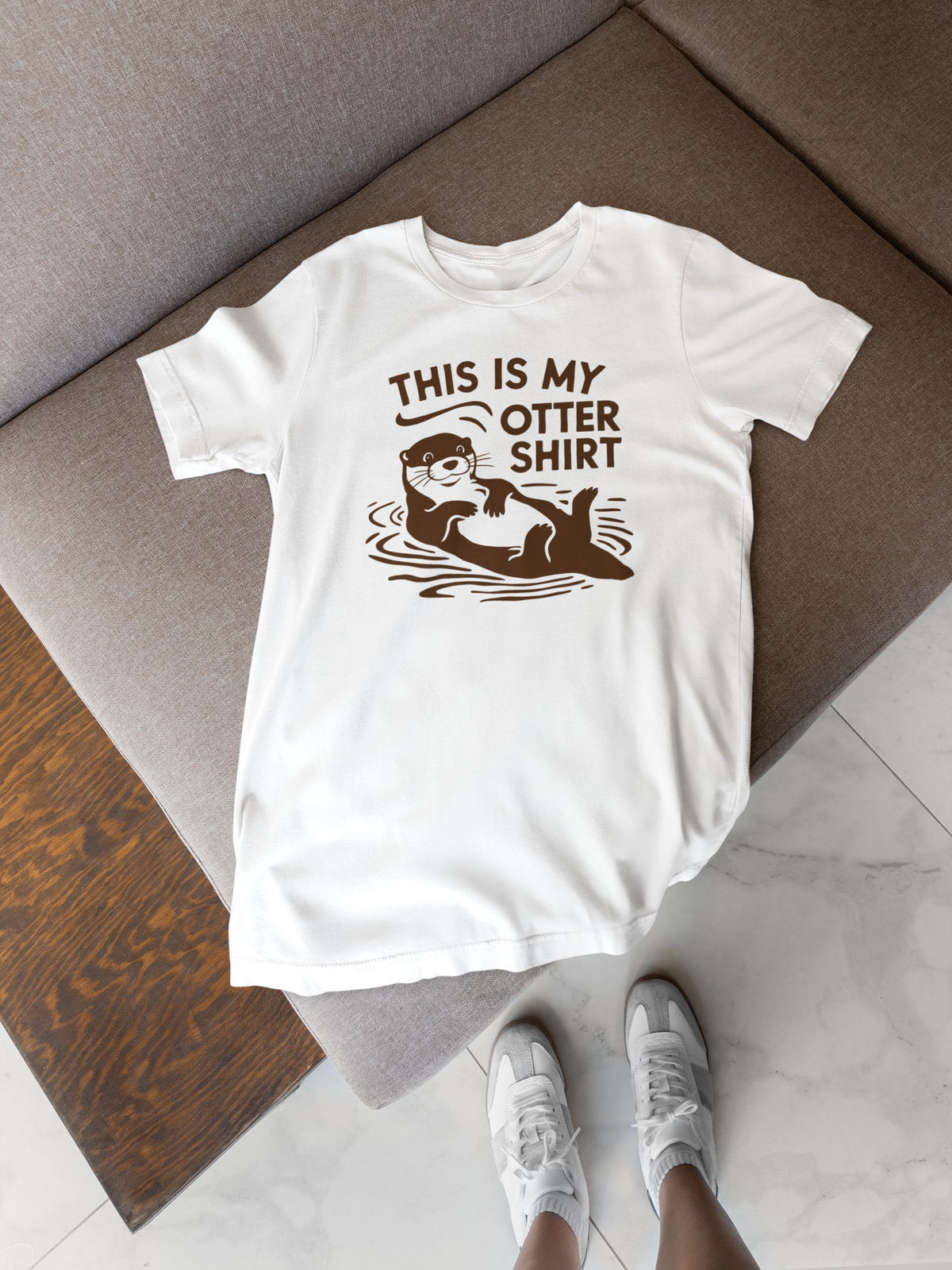 'This Is My Otter Shirt' t-shirt in white, flat lay on a wooden floor, funny animal pun gift