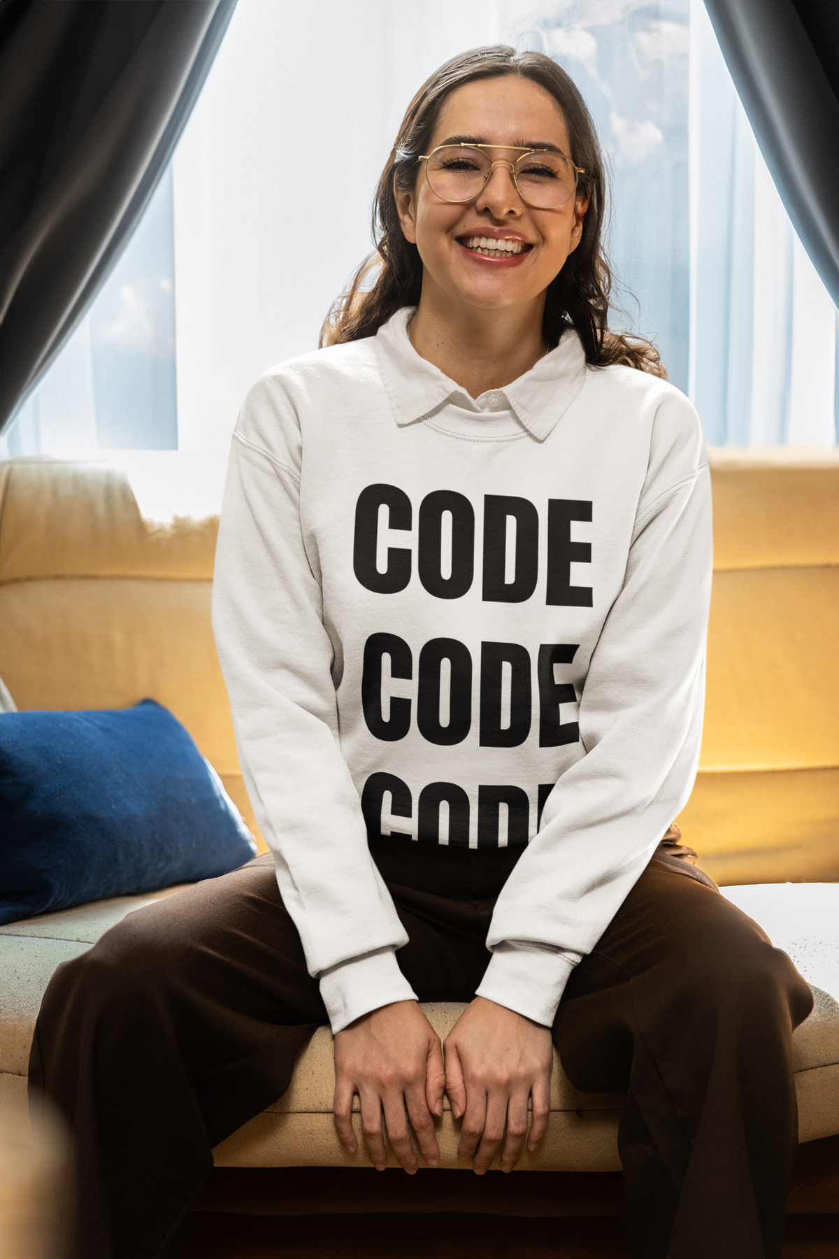 "Code Code Code" sweatshirt in white, woman sitting on a couch at home, funny developer gift sweatshirt
