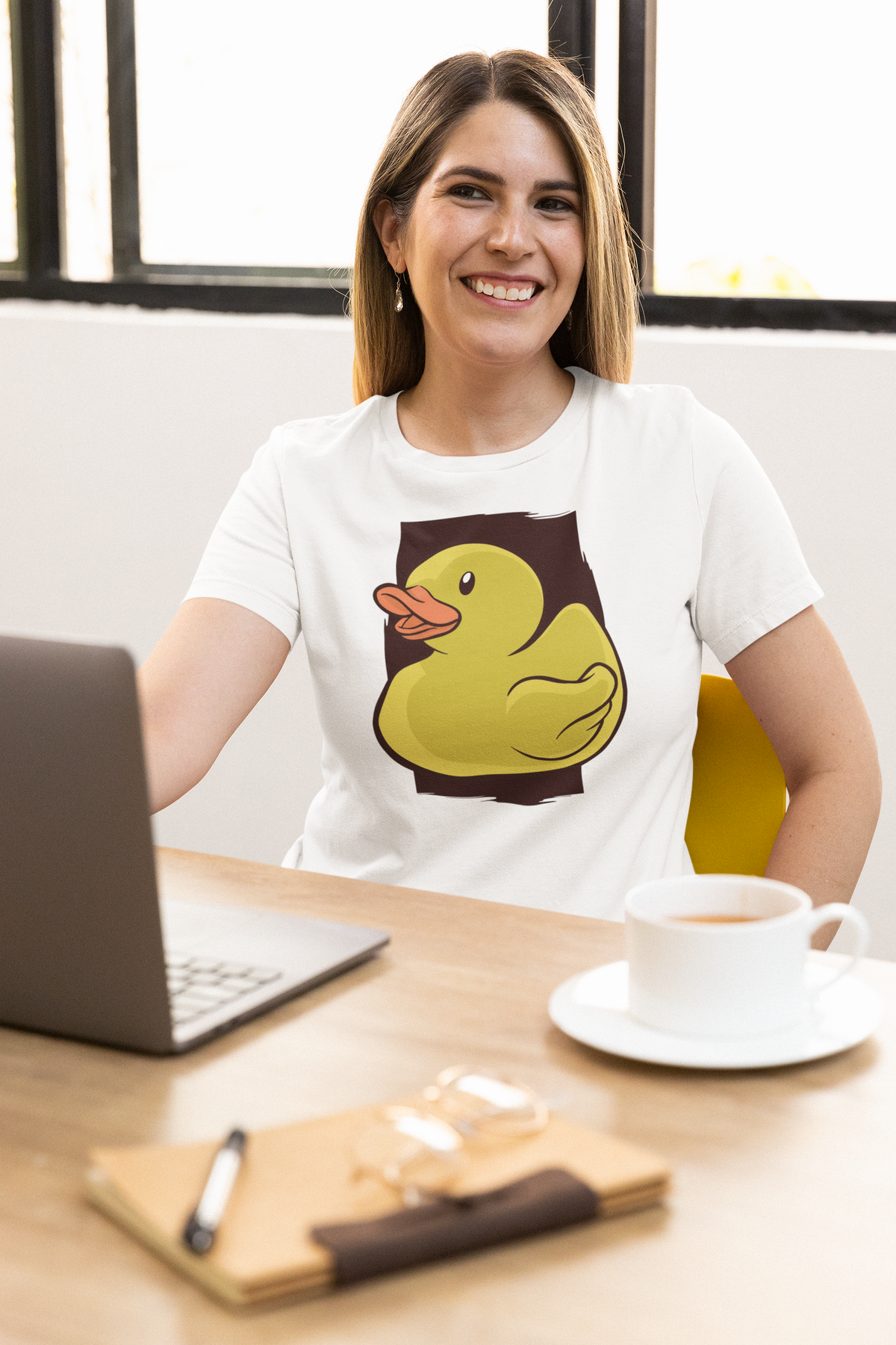 Classic rubber duck t-shirt in white, woman model wearing it at a desk with a laptop, funny duck lover gift