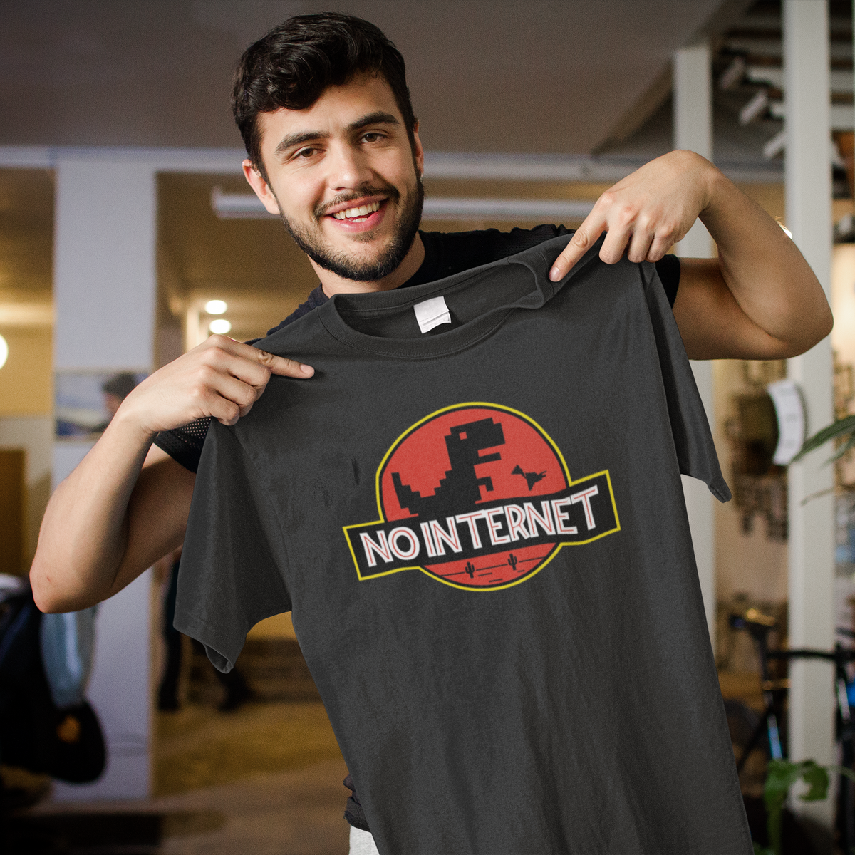 No Internet dinosaur logo tee in black, man holding it up and pointing, funny gift for movie fans