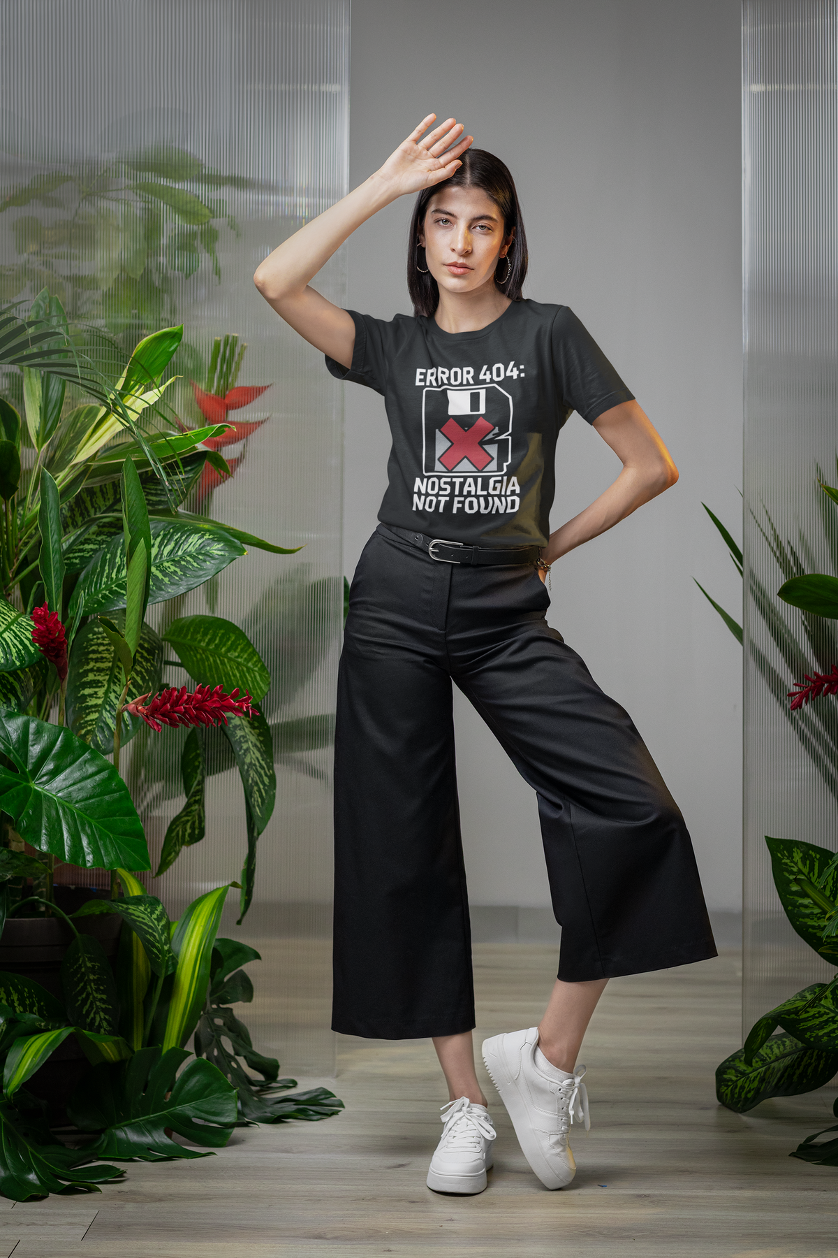 'Error 404: Nostalgia Not Found' tee in black, woman wearing it in tropical plant setting, funny developer gift