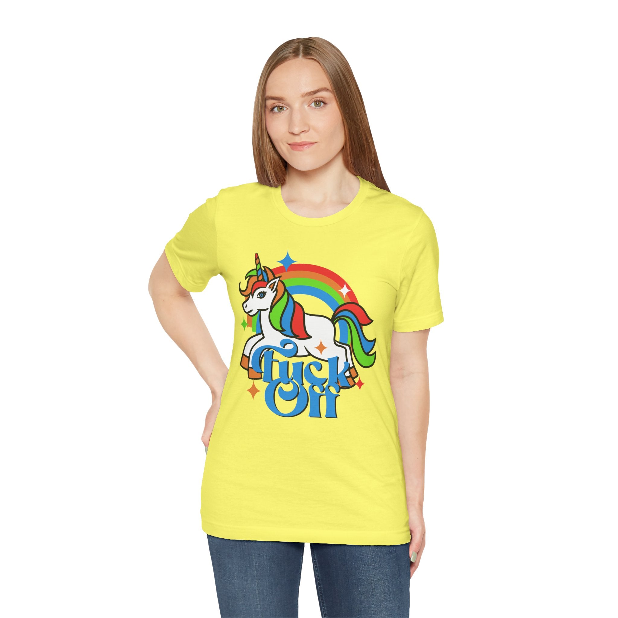 Woman in a yellow F off T-shirt featuring a colorful unicorn and a rainbow with the text "mystical.