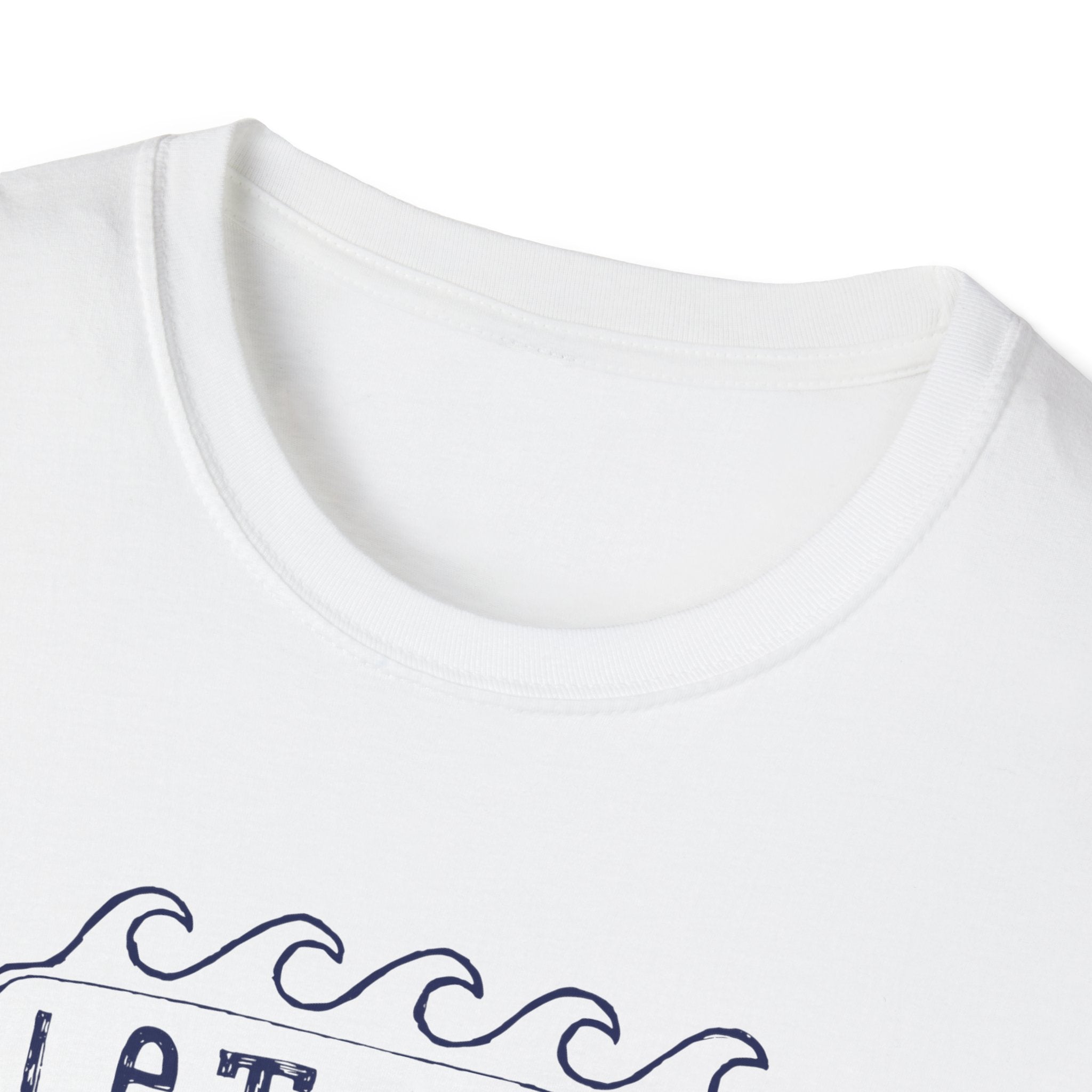 A close-up of a stylish tee showcases the "Let the Waves Take You On a Journey" T-shirt, featuring a white base with a navy wave design and partially visible text that symbolizes self-discovery.