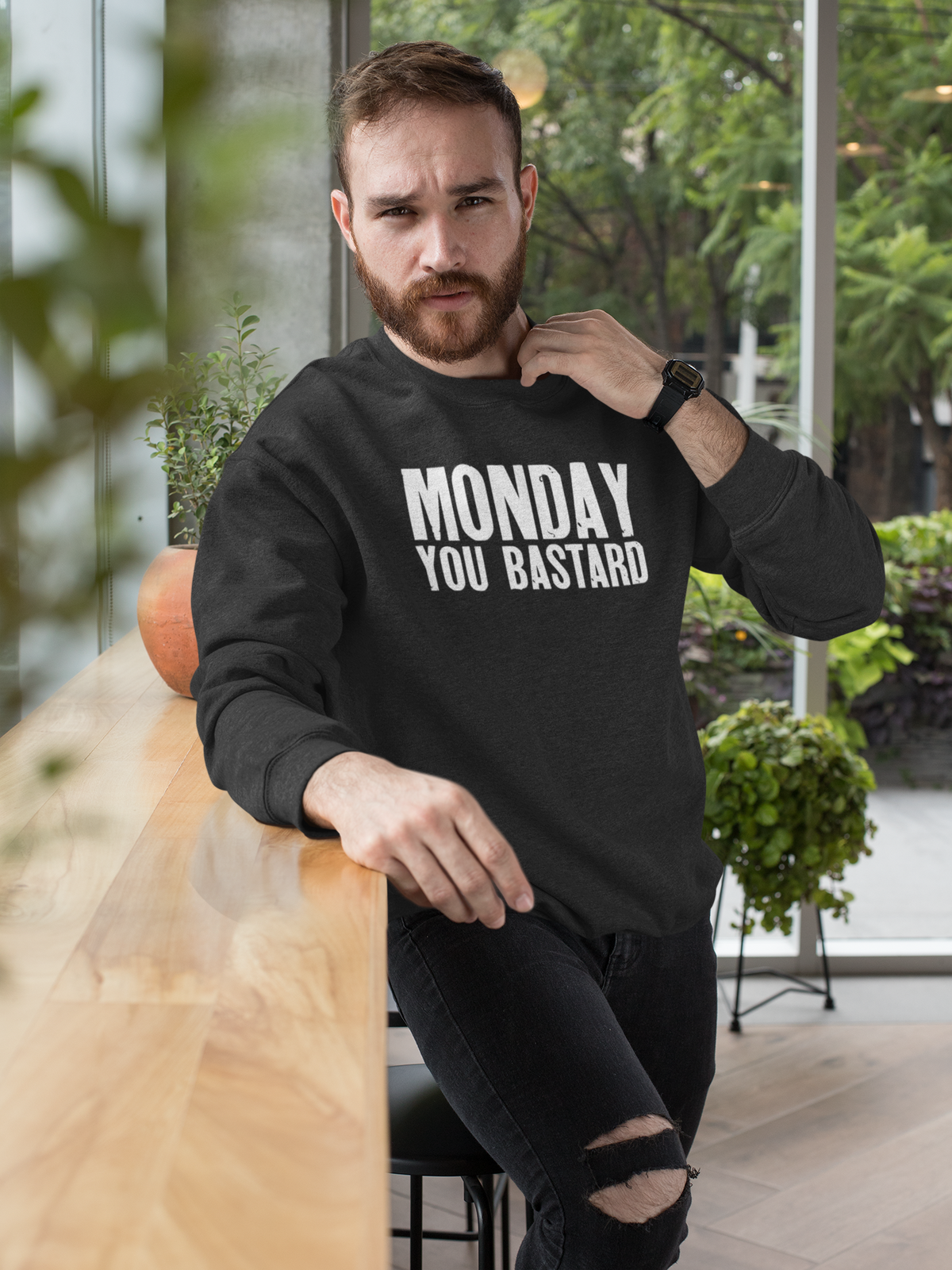 'Monday You Bastard' text sweatshirt in black, bearded man sitting outdoors, funny Monday humor gift
