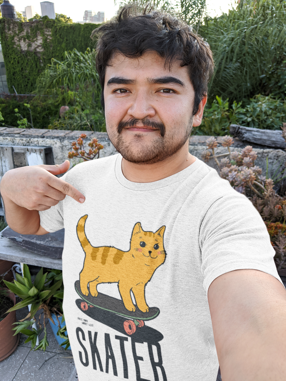 "Skater Kitty" cat on skateboard t-shirt in white, man wearing it outdoors, funny cat lover gift