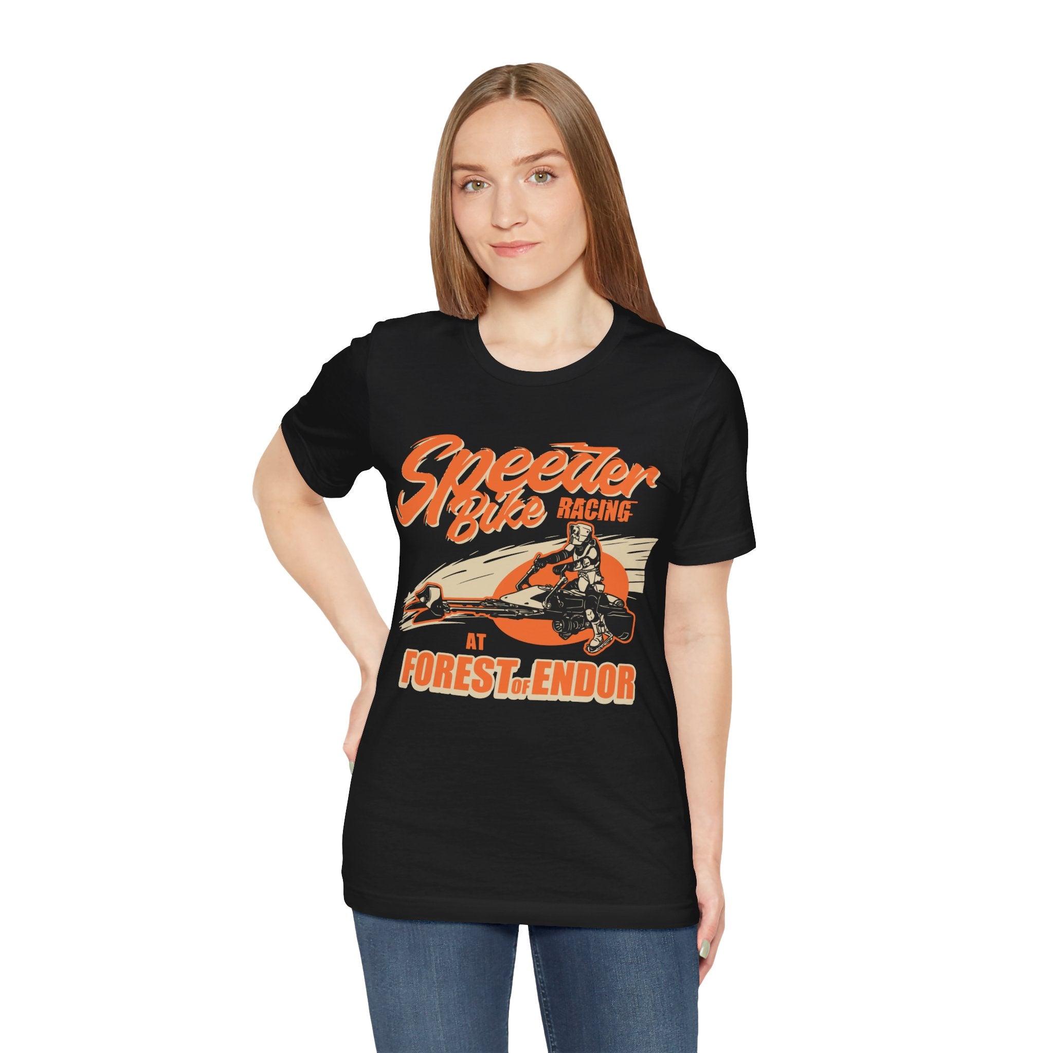 Sentence with product name: A woman wearing a black jersey tee with "Speeder Bike Racing" graphic print at Forest of Endor.
