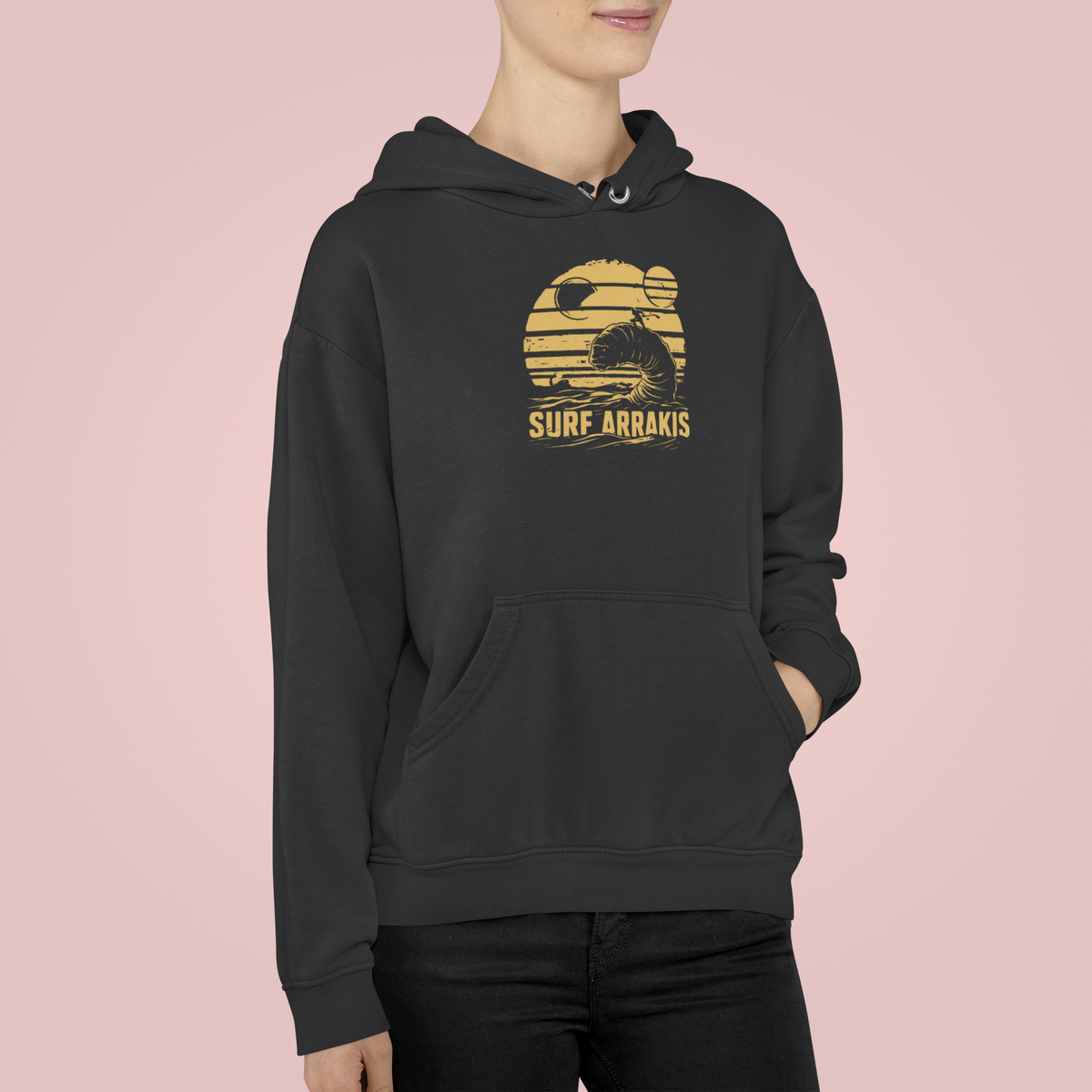 Surf Arrakis sandworm hoodie in black, woman wearing it on a pink background, funny sci-fi gift