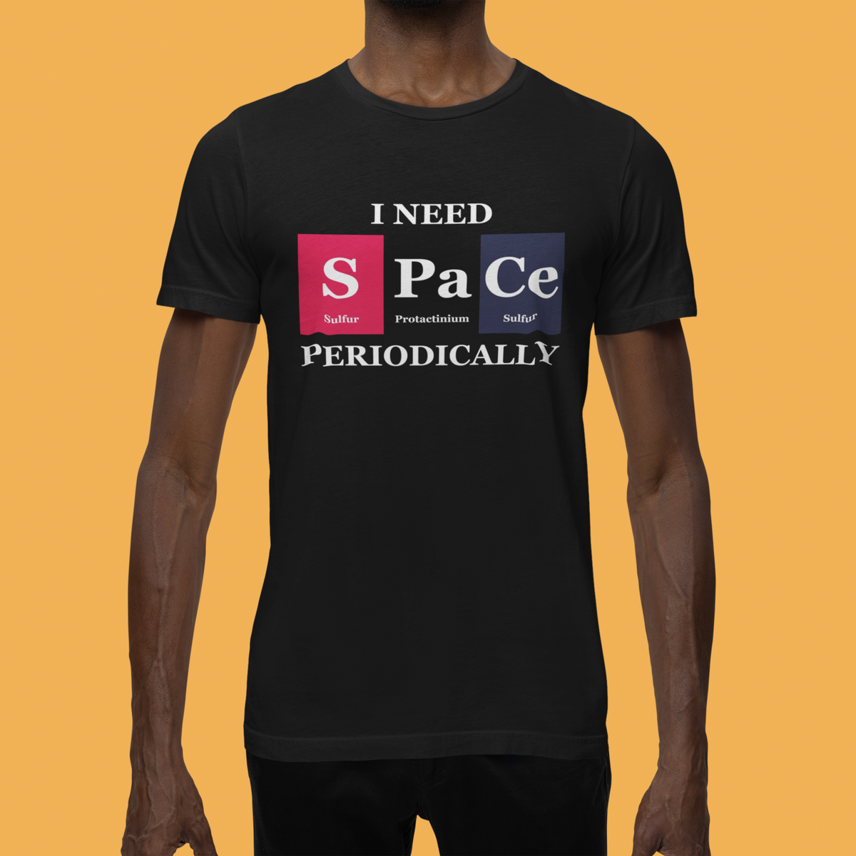 'I Need Space Periodically' periodic table t-shirt in black, man wearing it on orange background, funny gift