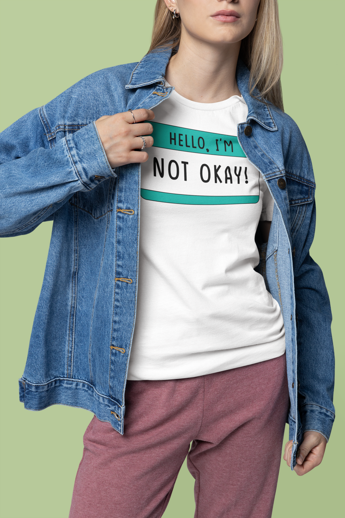 Hello I'm Not Okay name tag T-shirt in white, woman wearing denim jacket over it, sarcastic gift tee