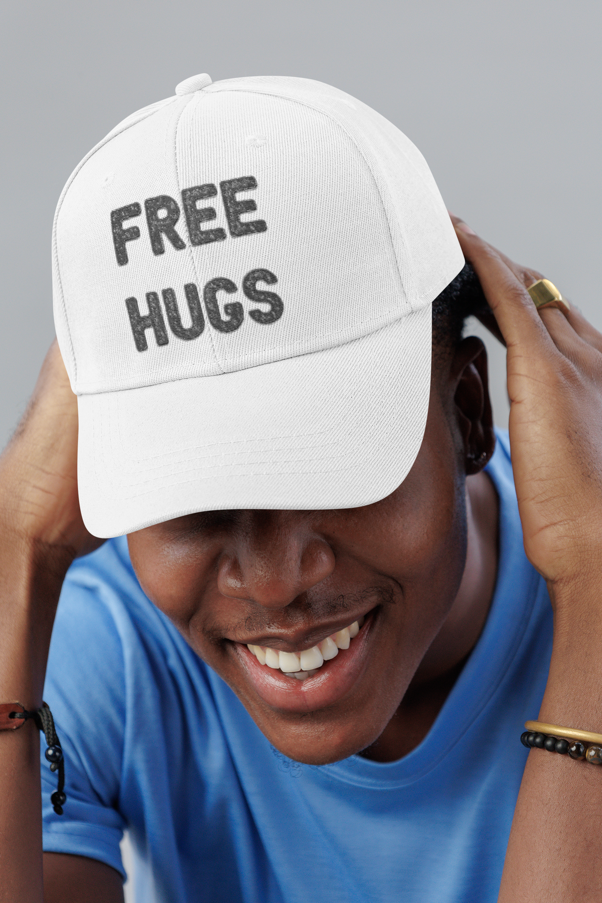 Free Hugs embroidered dad hat, smiling man in a studio, lifestyle mockup, Geekpsters