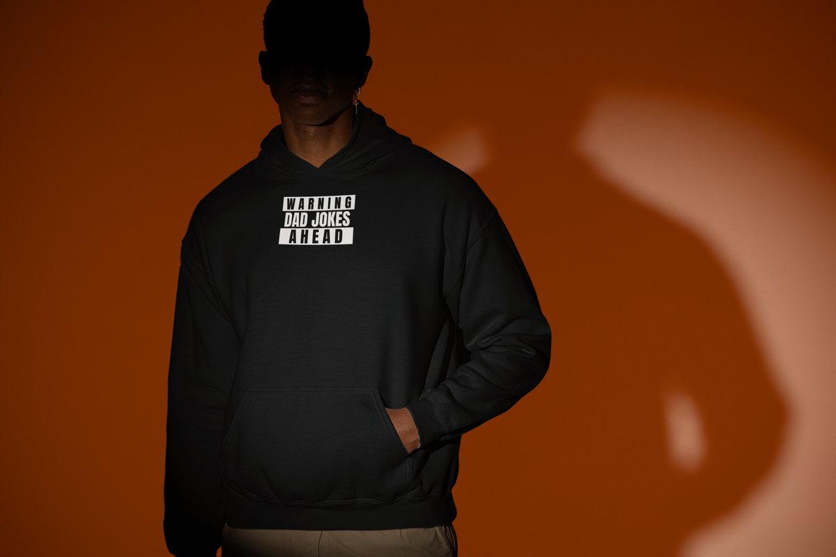 'Warning Dad Joke Ahead Hoodie' in black, man under a spotlight, Hoodie mockup, Geekpsters