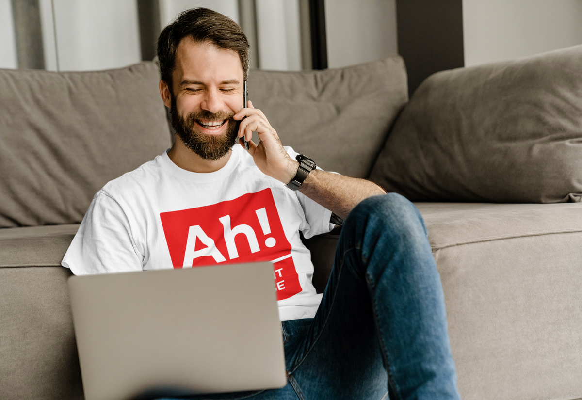 'Ah! The Element of Surprise' T-shirt in white, man relaxing on a couch wearing it, science gift