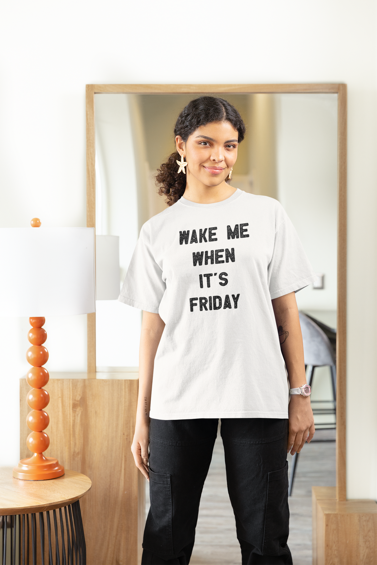 'Wake Me When It's Friday' women's t-shirt in white, woman wearing it at home, work gift
