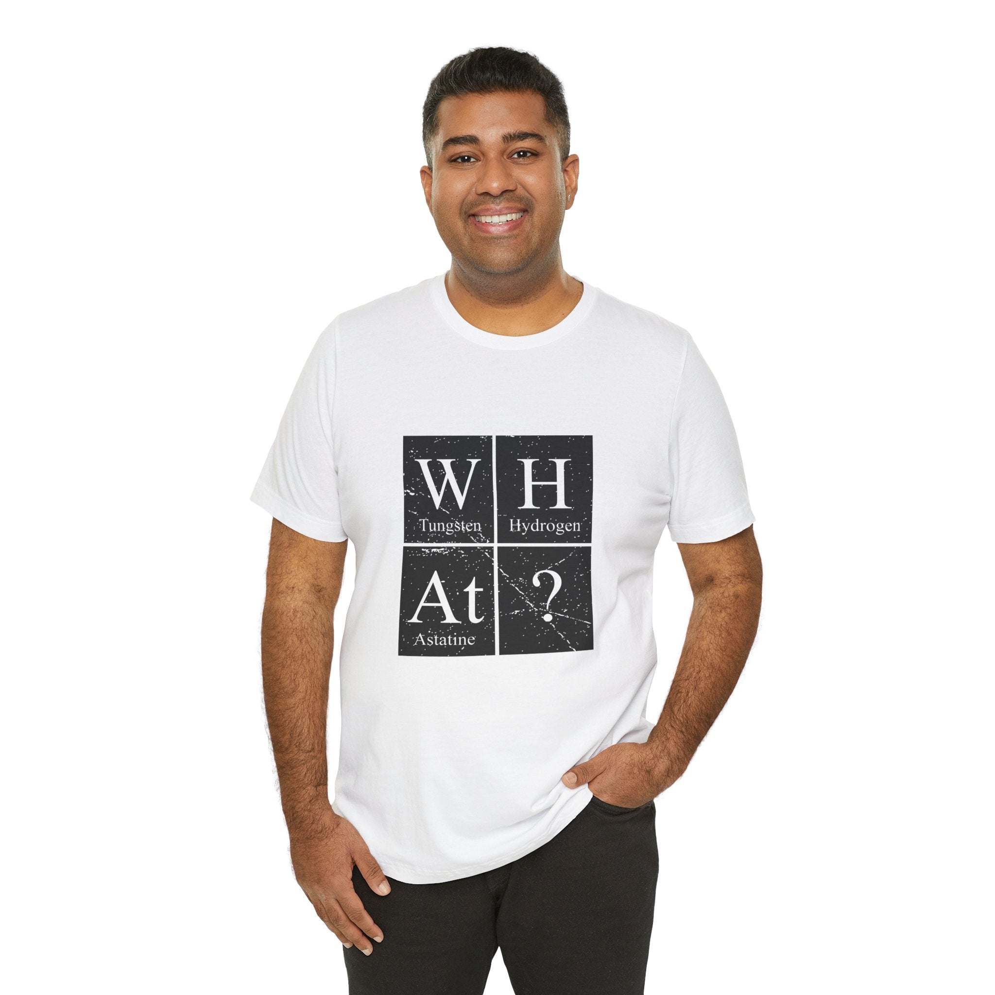 A man smiling at the camera, wearing a white unisex W-H-At-? tee with a periodic table design, stands against a white background.
