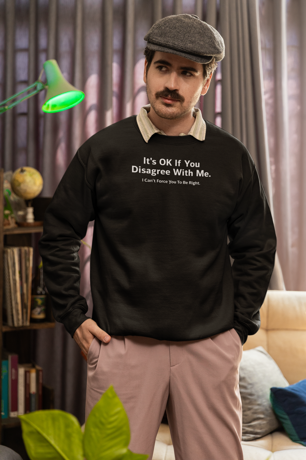 'It's Ok If You Disagree Sweatshirt' in black, man in a cozy living room, Sweatshirt mockup, Geekpsters