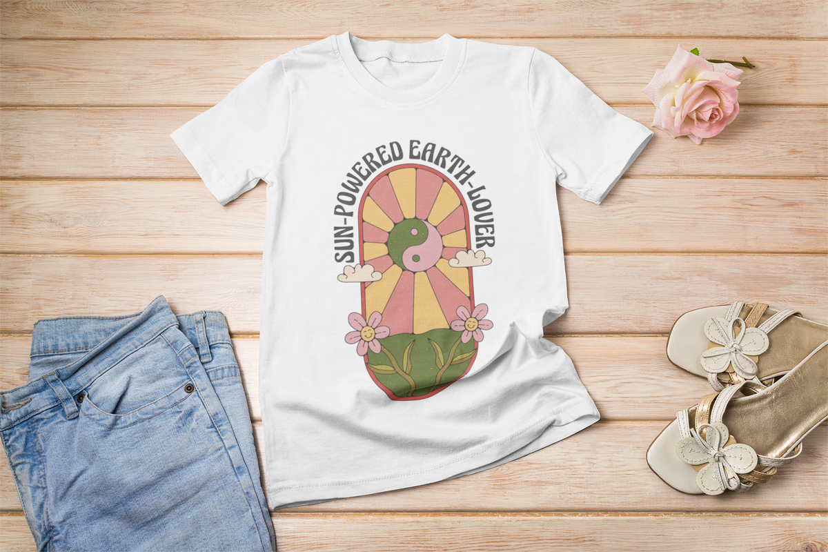 'Sun Powered Earth Lover' t-shirt in white, flat lay styled with denim and sandals