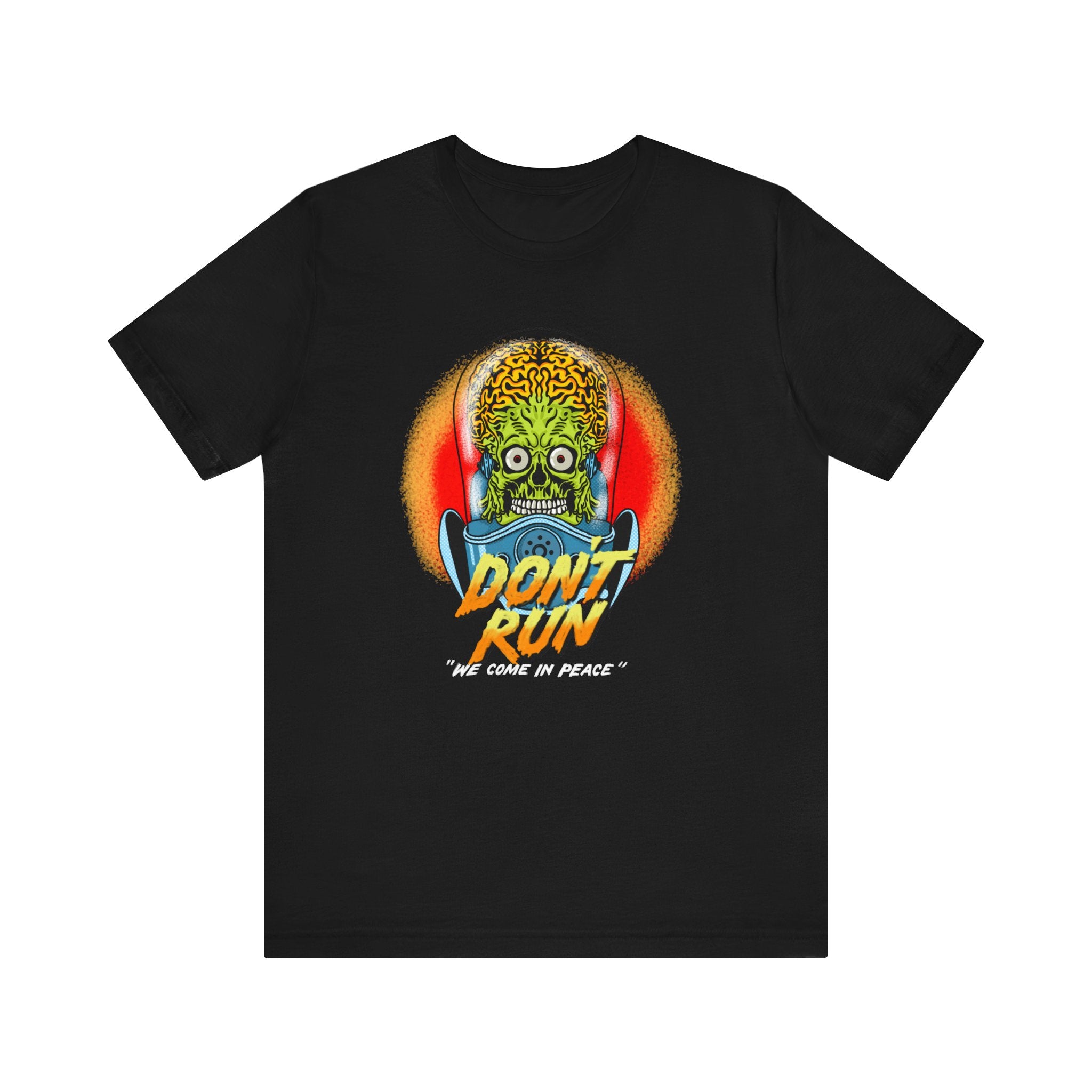 The Don't Run T-Shirt features a graphic of a skull with alien features and a brain, with the text "don't run 'we come in peace'" underneath. This unisex jersey tee is made from soft cotton.