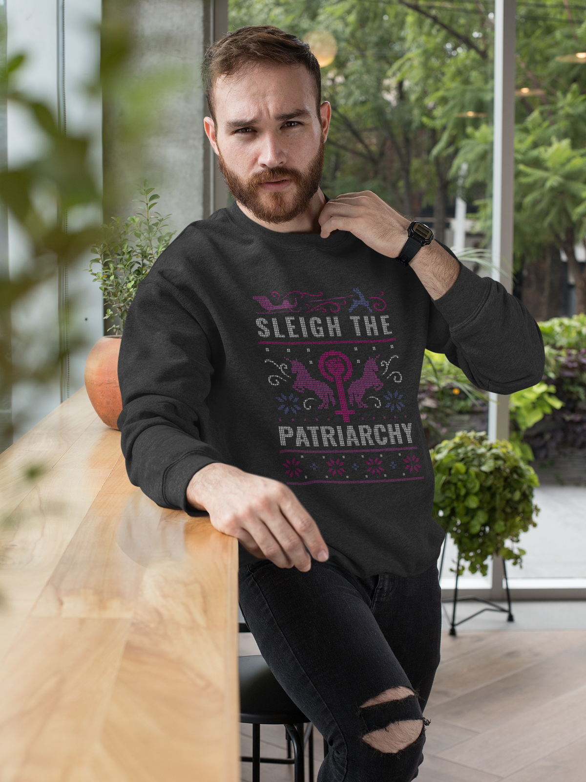 'Sleigh the Patriarchy' ugly sweater sweatshirt in black, bearded man wearing it outdoors, feminist gift
